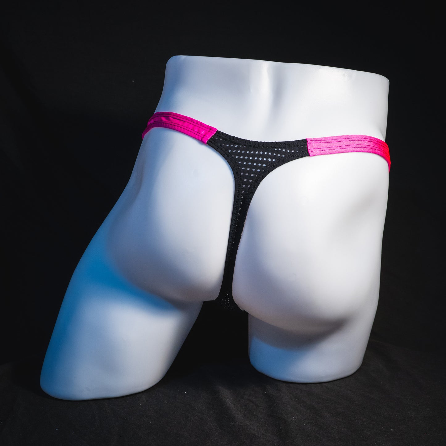 Men's bright pink and black mesh thong underwear, classic cut, full rear view.