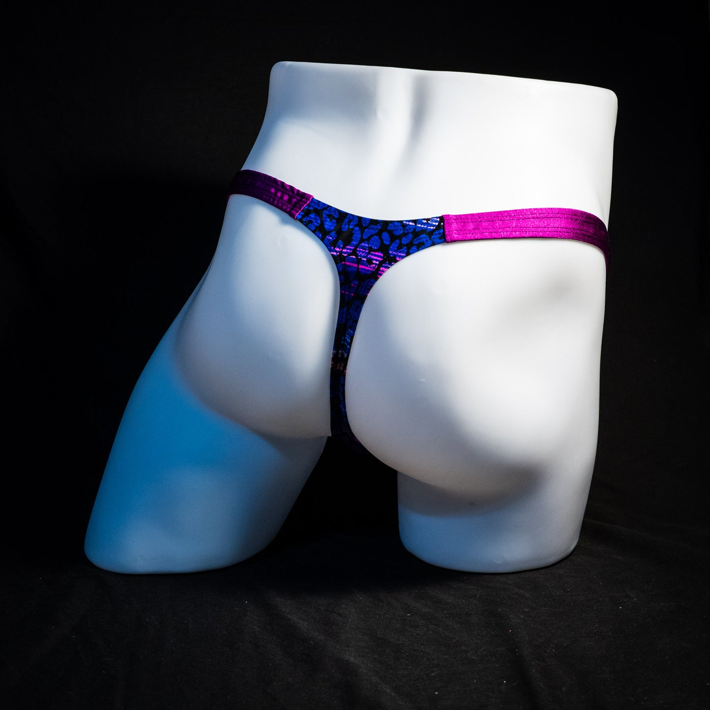 Men's purple and blue thong underwear, classic cut, full rear angled view.