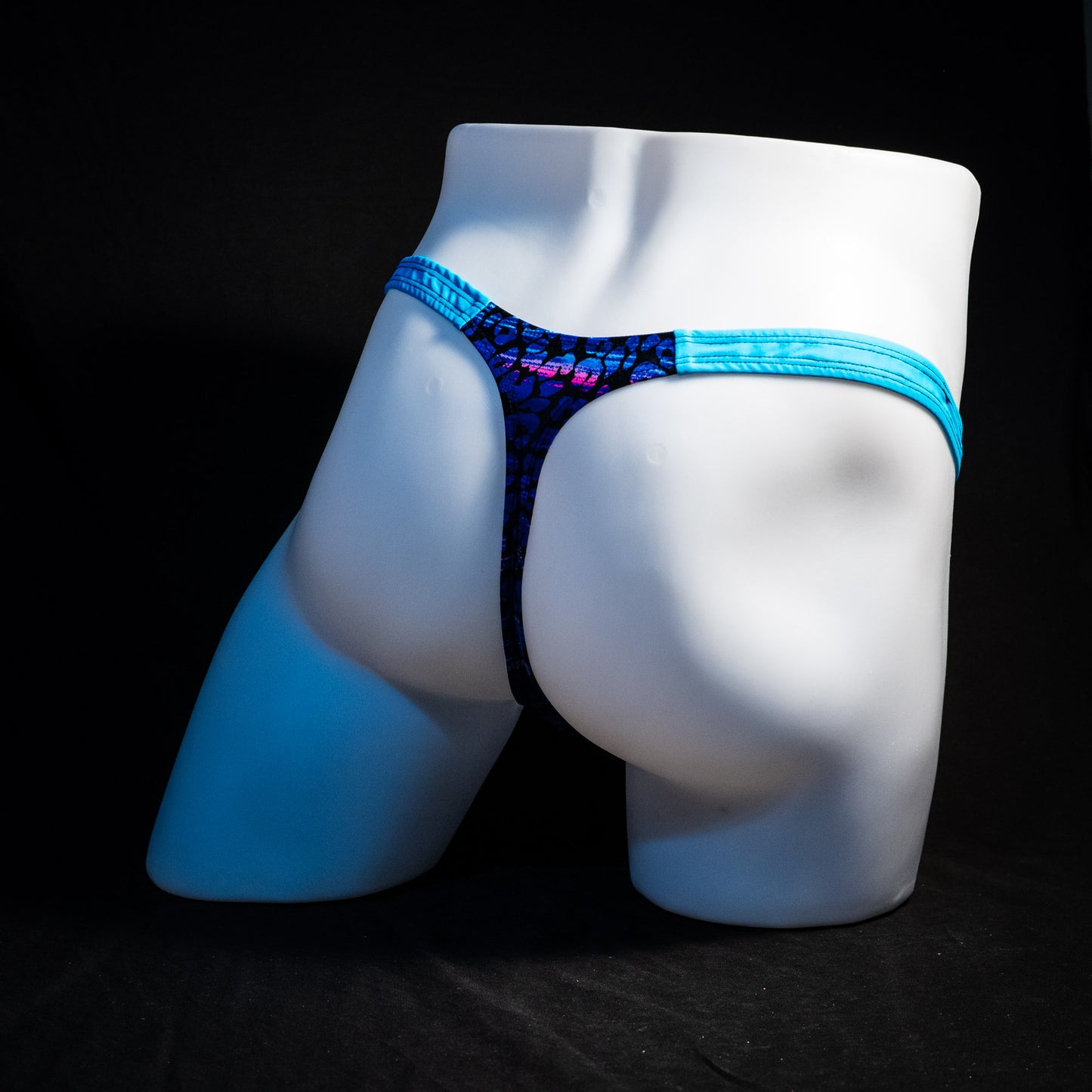 Men's purple and blue cheetah thong underwear, classic cut, full rear angled view.