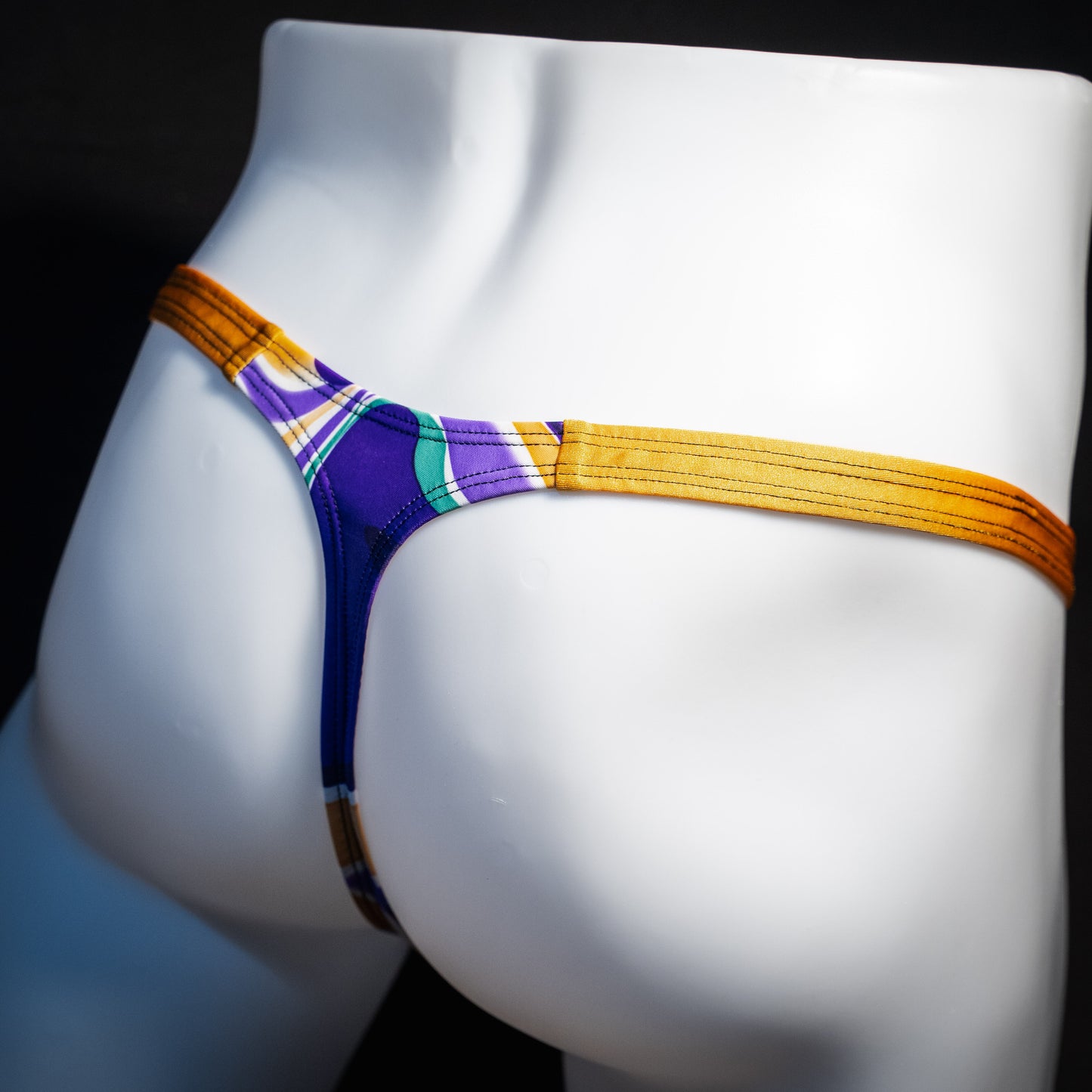 Men's purple and copper psychedelic thong underwear, classic cut, rear view.
