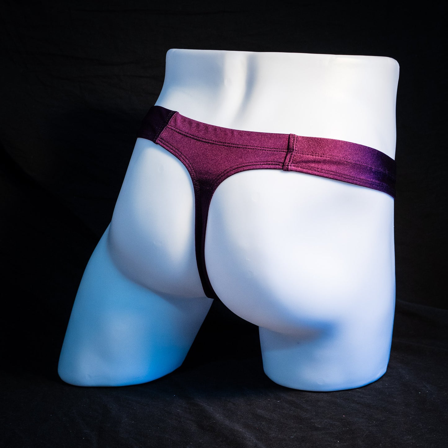 Men's purple pouchless thong underwear, full rear angled view.