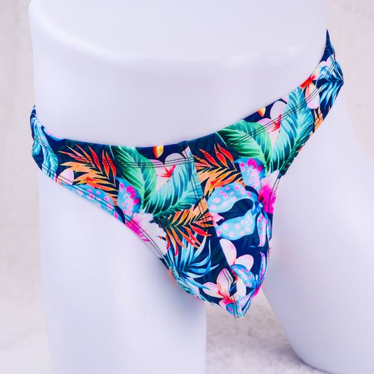 Tropical leaf patterned mens thong on a white mannequin.
