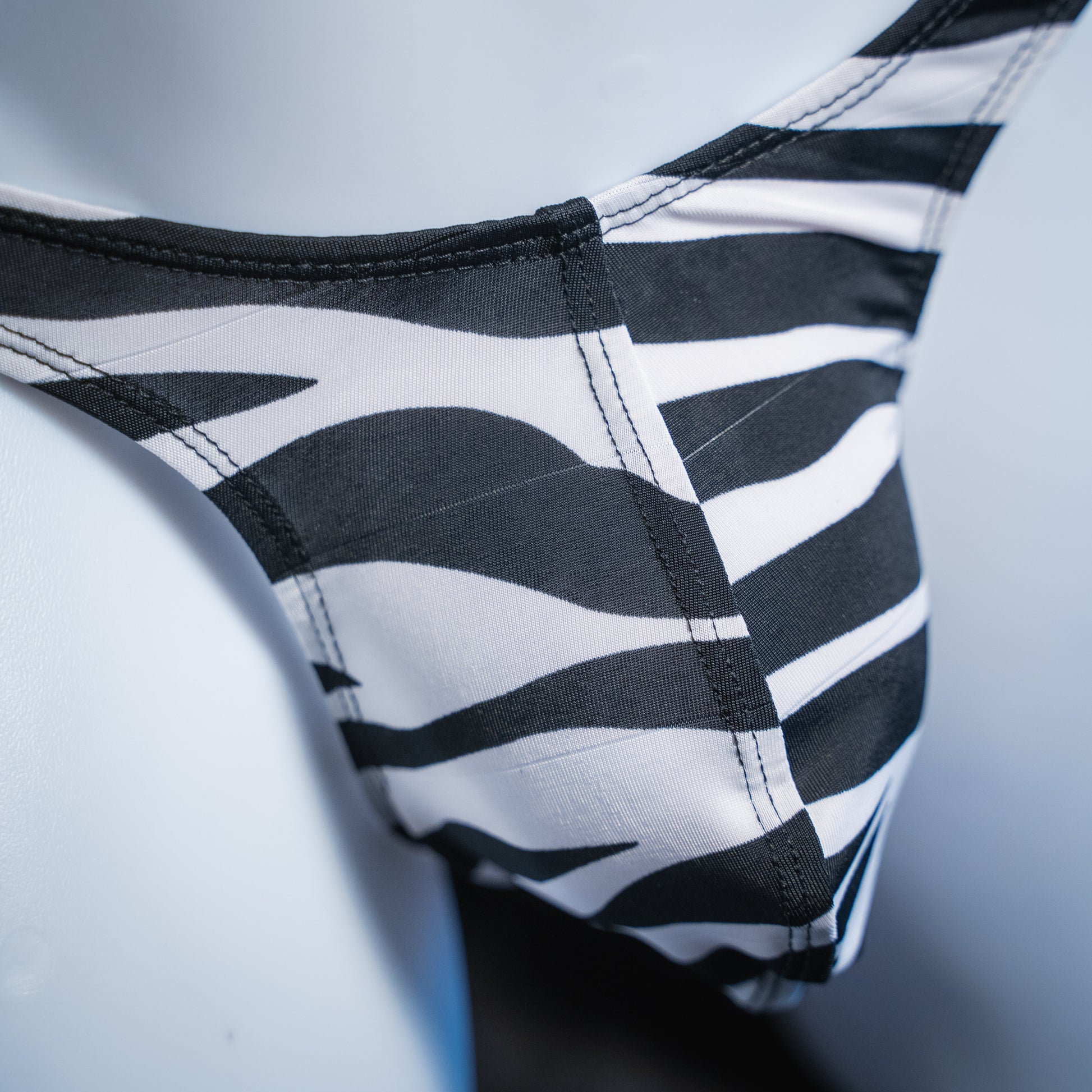 Men's zebra spandex thong, slim cut, closeup front view.