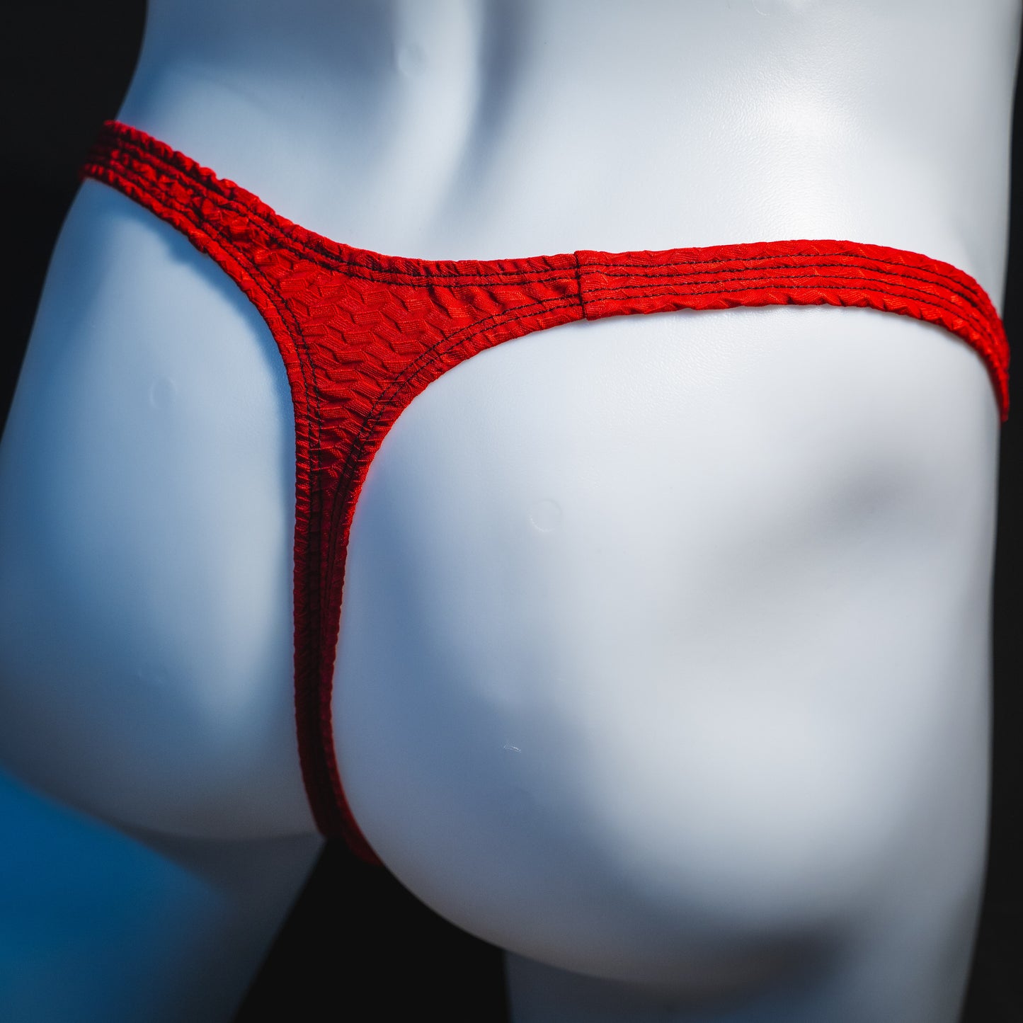 Men's bohemian red thong underwear, classic cut, angled rear view.