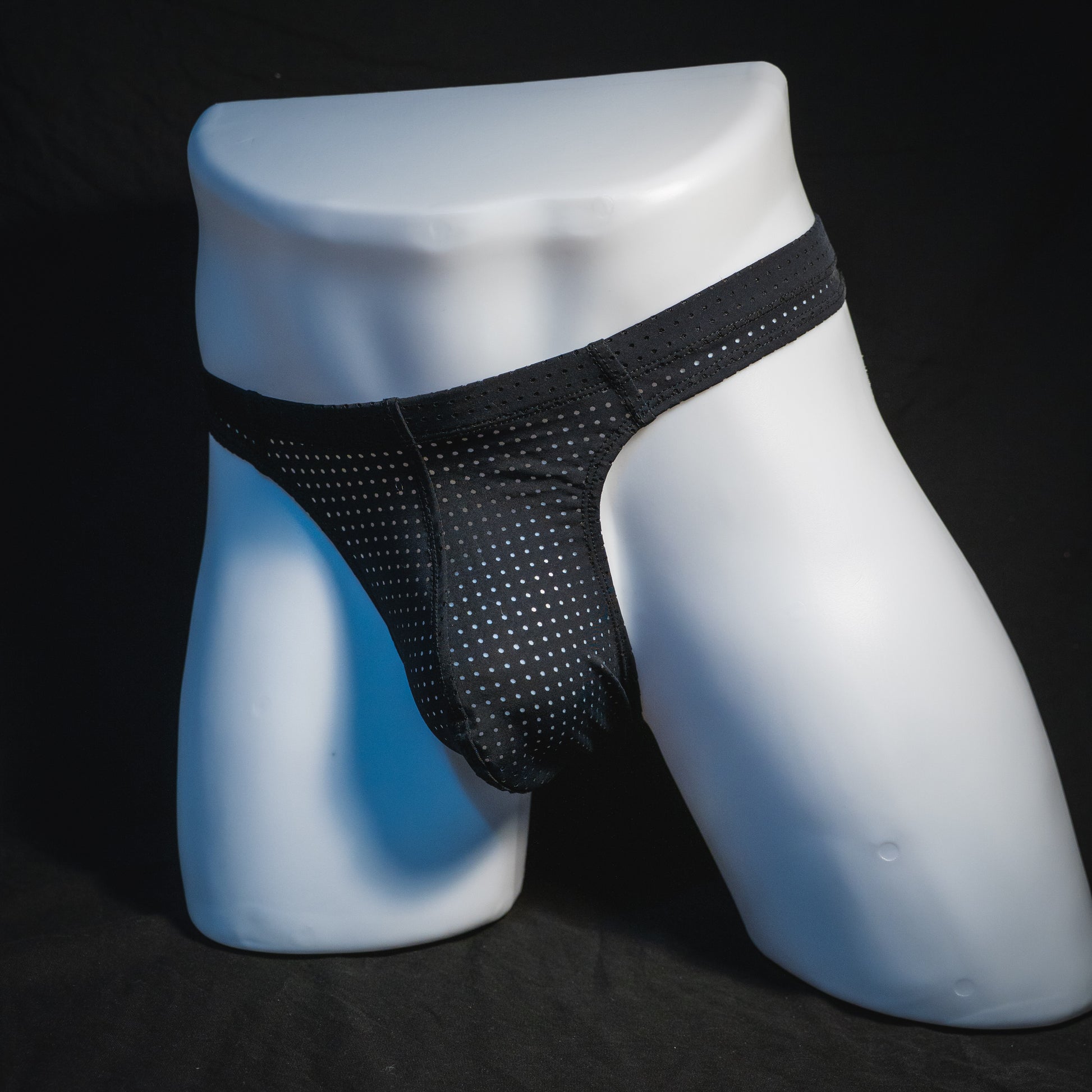 Men's black mesh pre-release thong underwear, angled full front view.