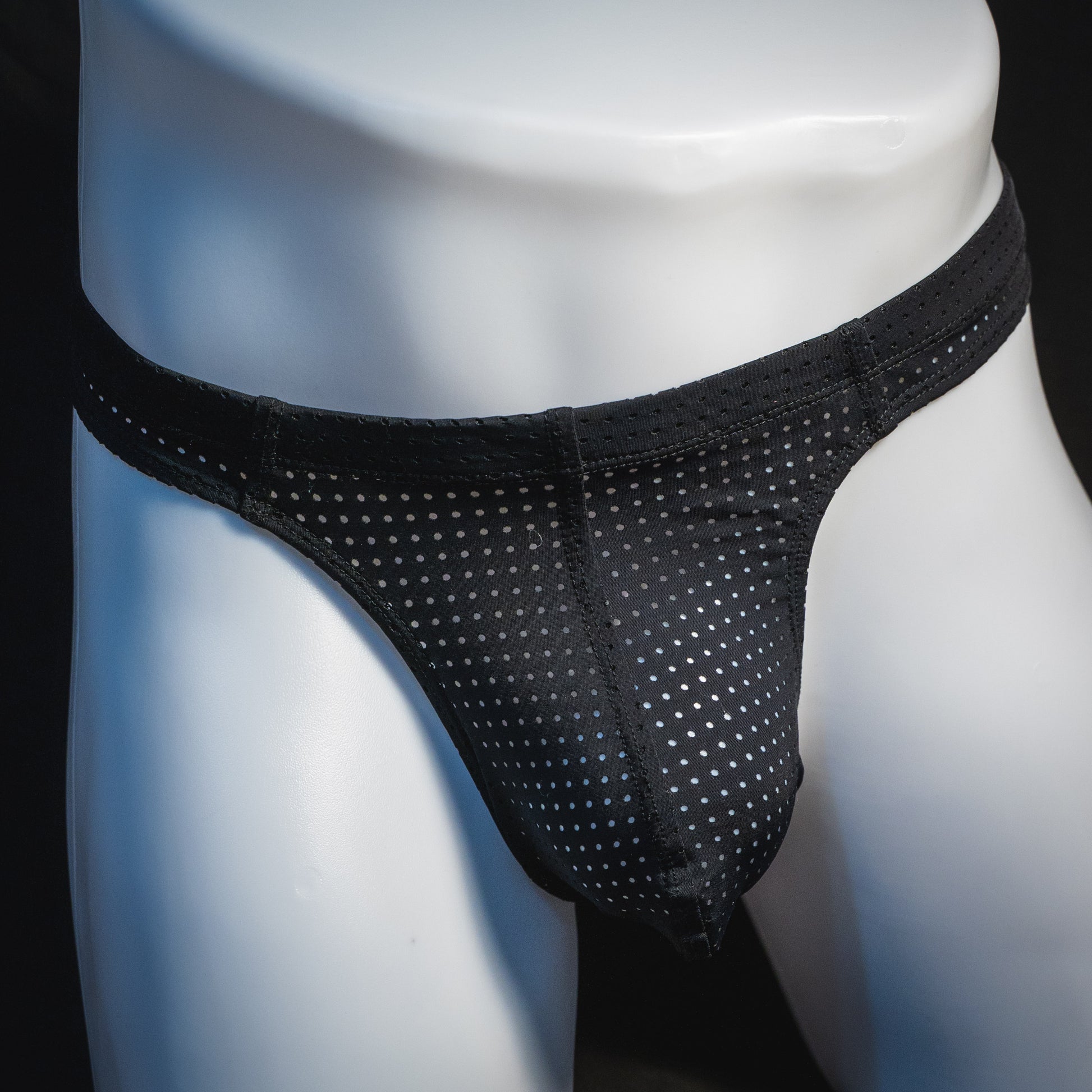 Men's black mesh pre-release thong underwear, front view.