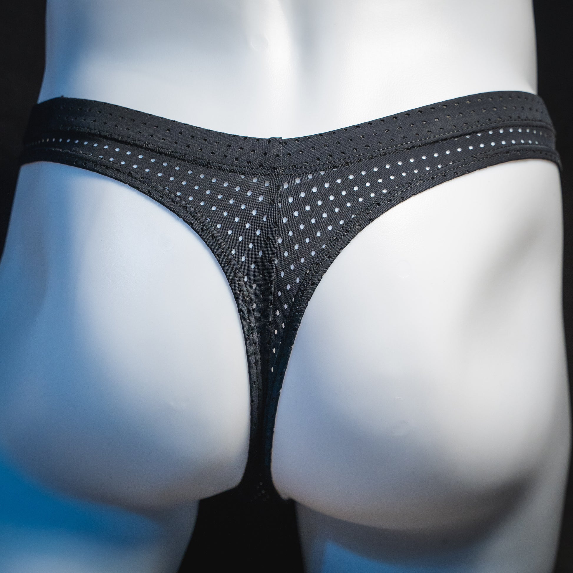 Men's black mesh pre-release thong underwear, rear view.