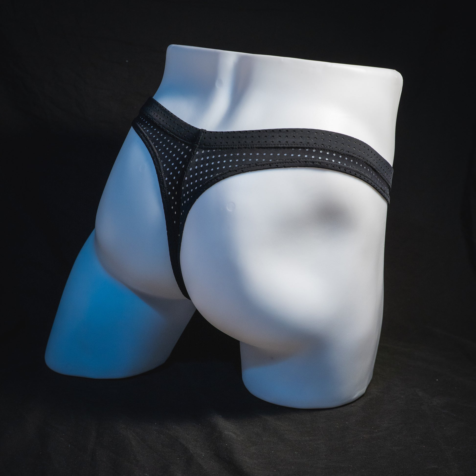 Men's black mesh pre-release thong underwear, angled full rear view.