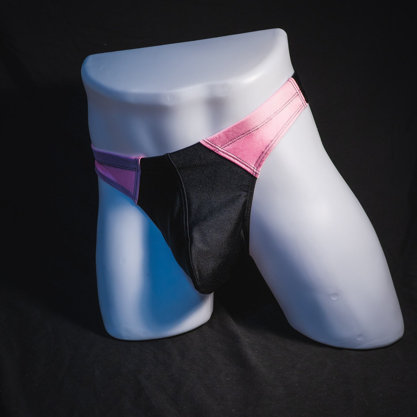 Men's pink and black thong underwear. contour cut, full front angled view.