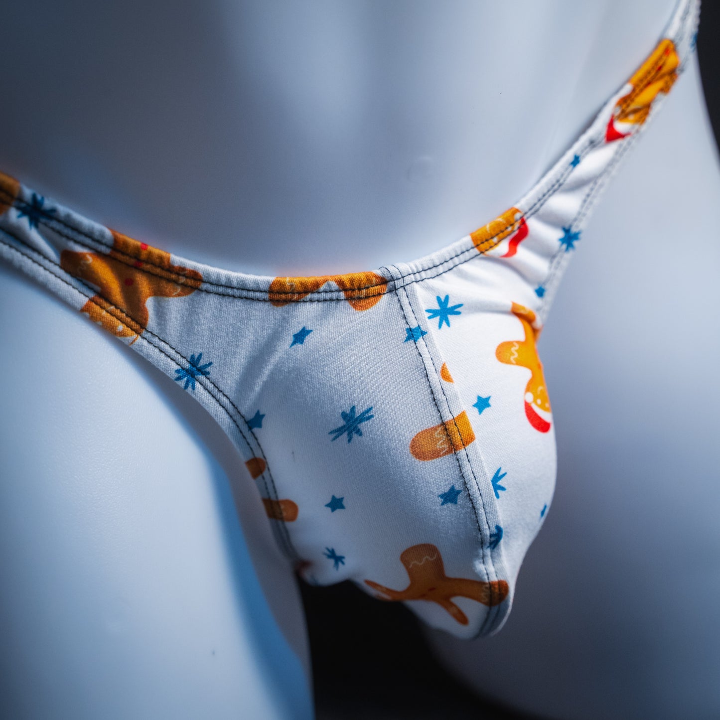Men's white with gingerbread men thong underwear, slim cut, Front view.