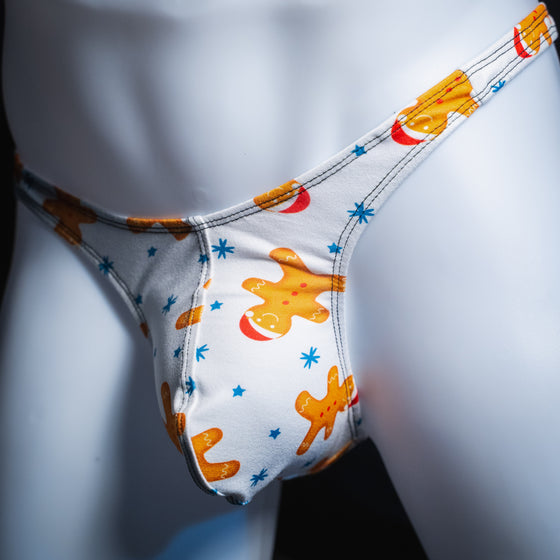 Men's white with gingerbread men thong underwear, slim cut, Angled front view.