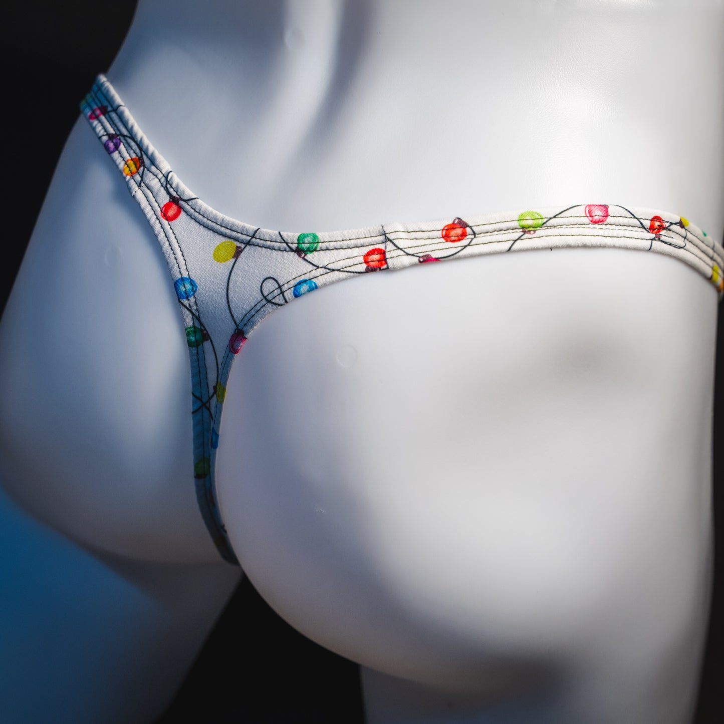 Men's Christmas lights thong underwear, angled rear view.