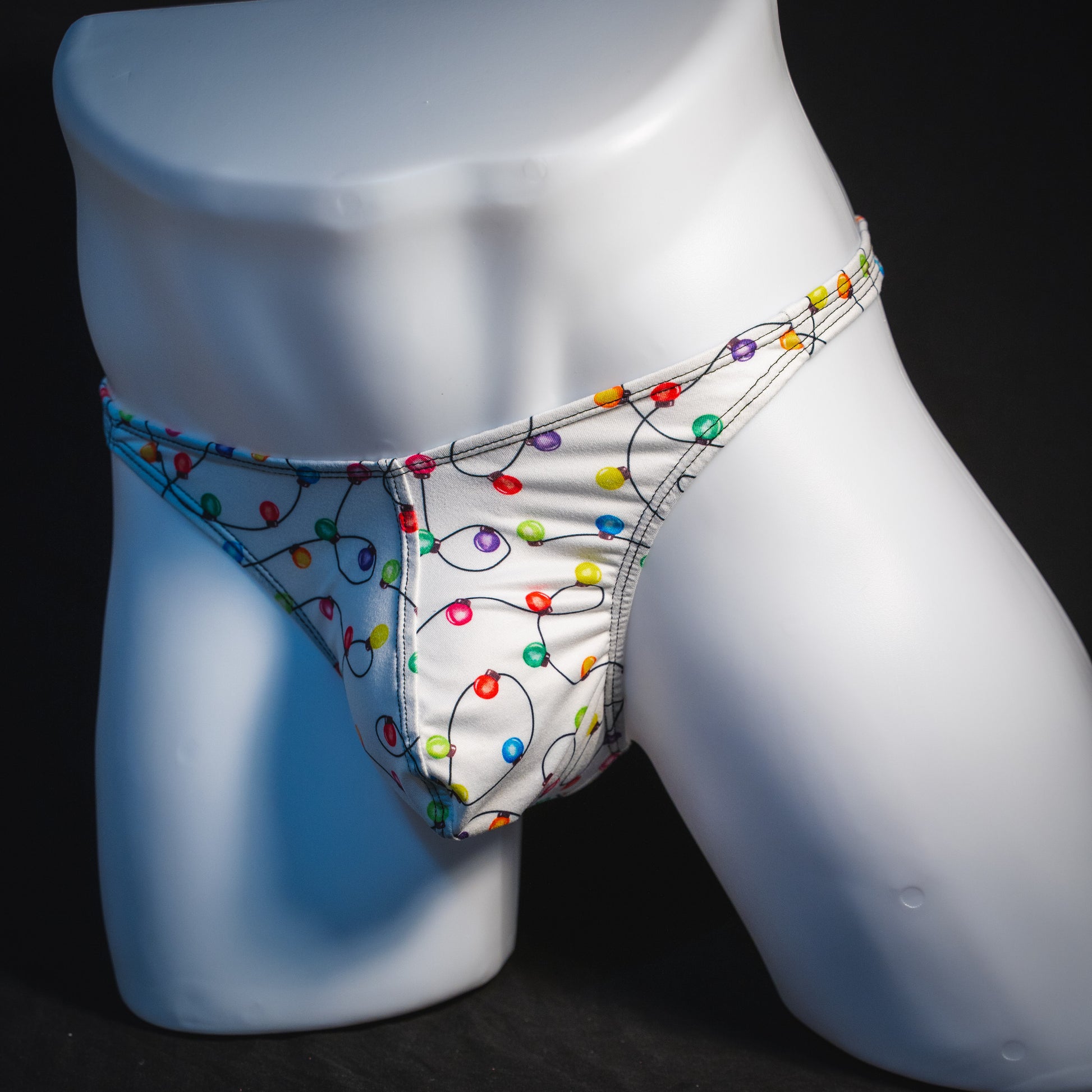 Men's Christmas lights thong underwear, angled full front view.
