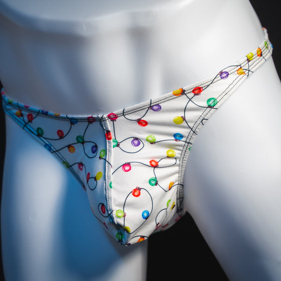 Men's Christmas lights thong underwear, angled front view.