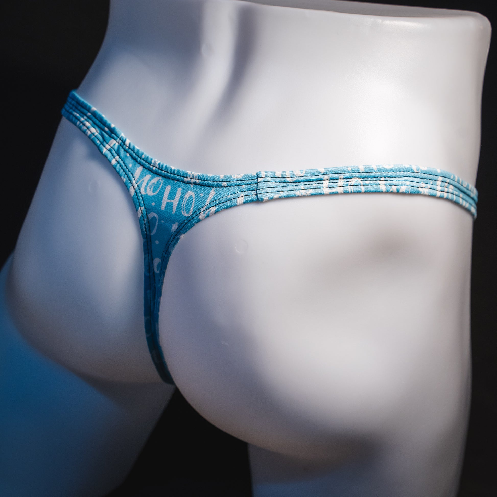 Men's Christmas thong underwear, slim cut, angled rear view.