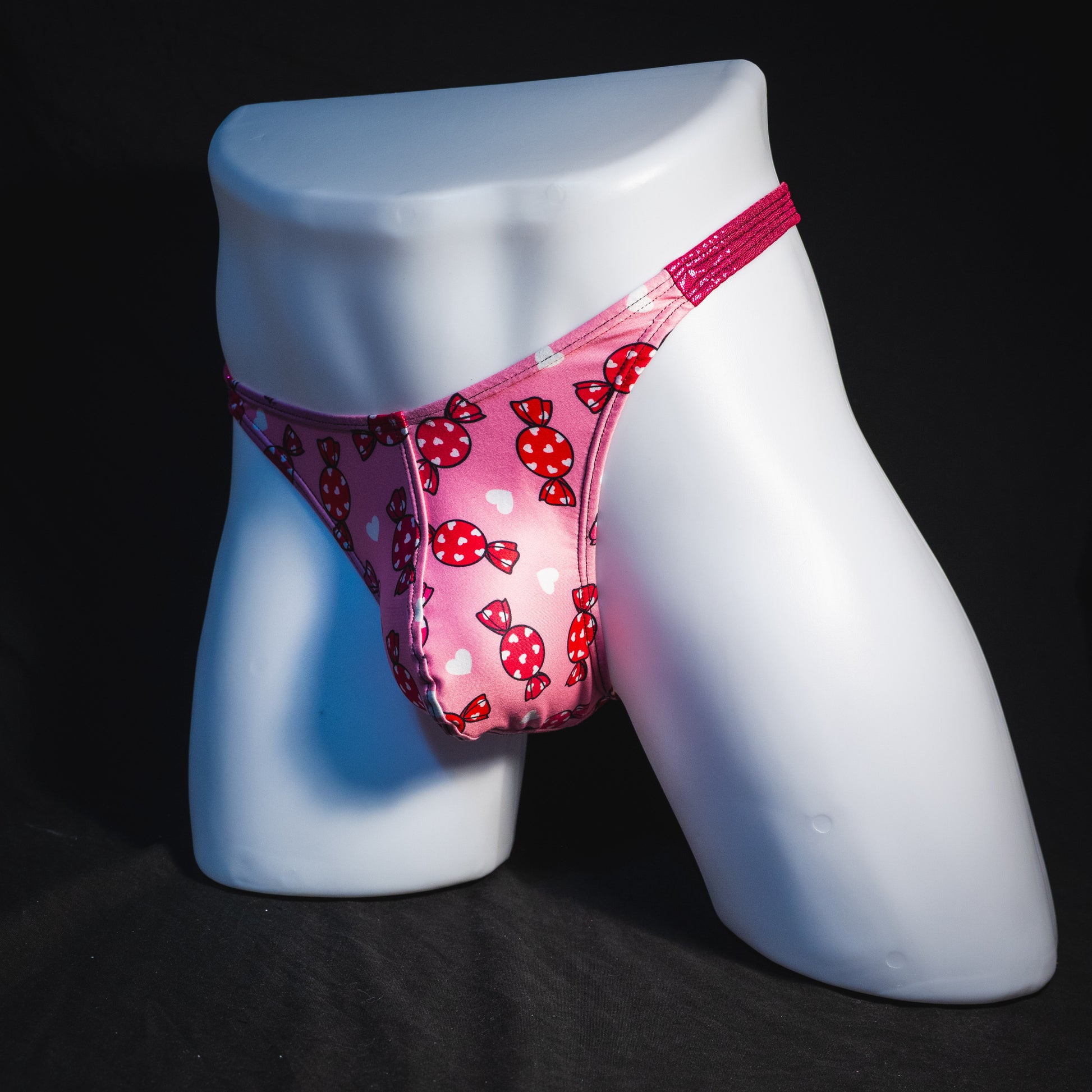 Men's Valentine Days candies with pink metallic straps thong underwear, classic cut, full angled front view.