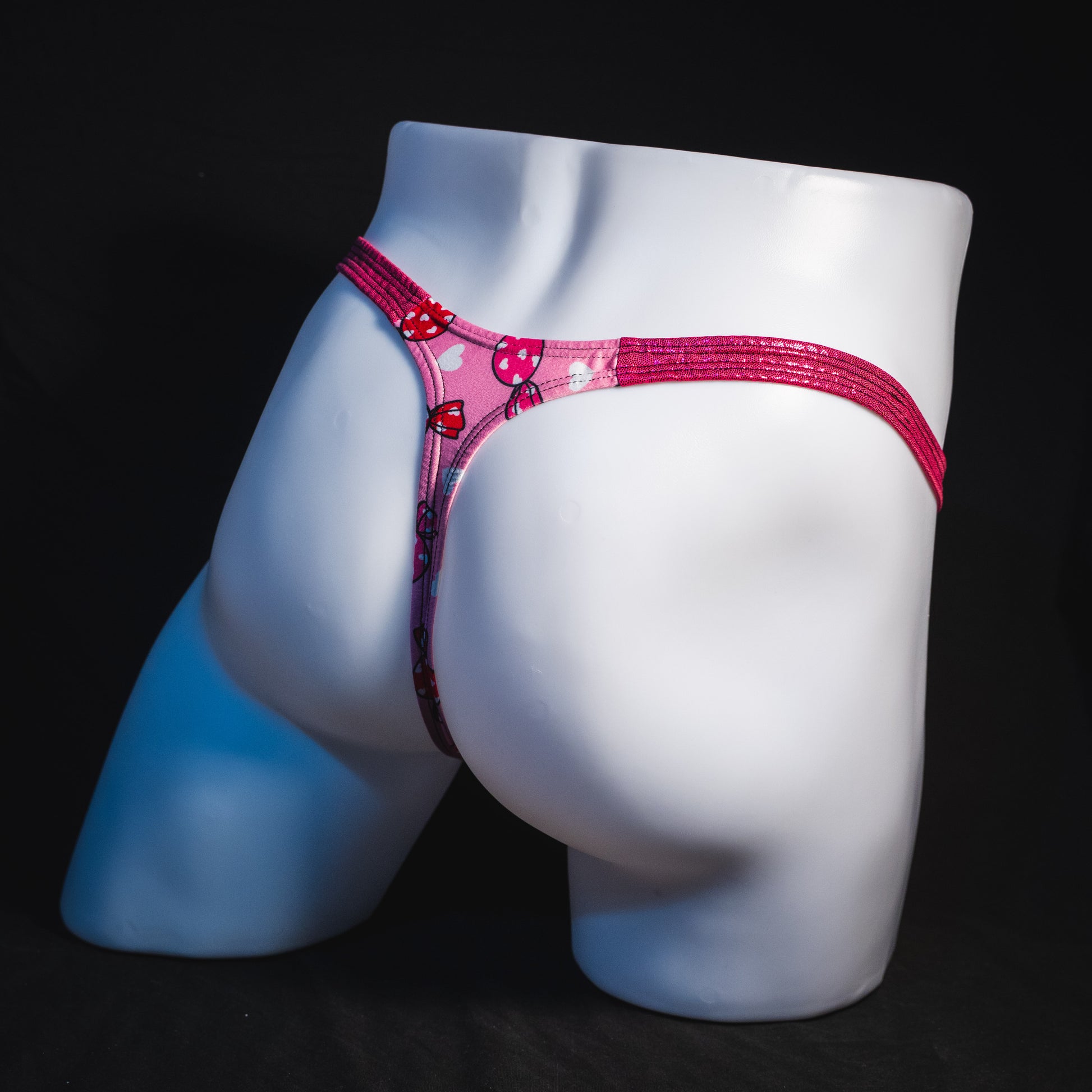 Men's Valentine Days candies with pink metallic straps thong underwear, classic cut, full angled rear view.