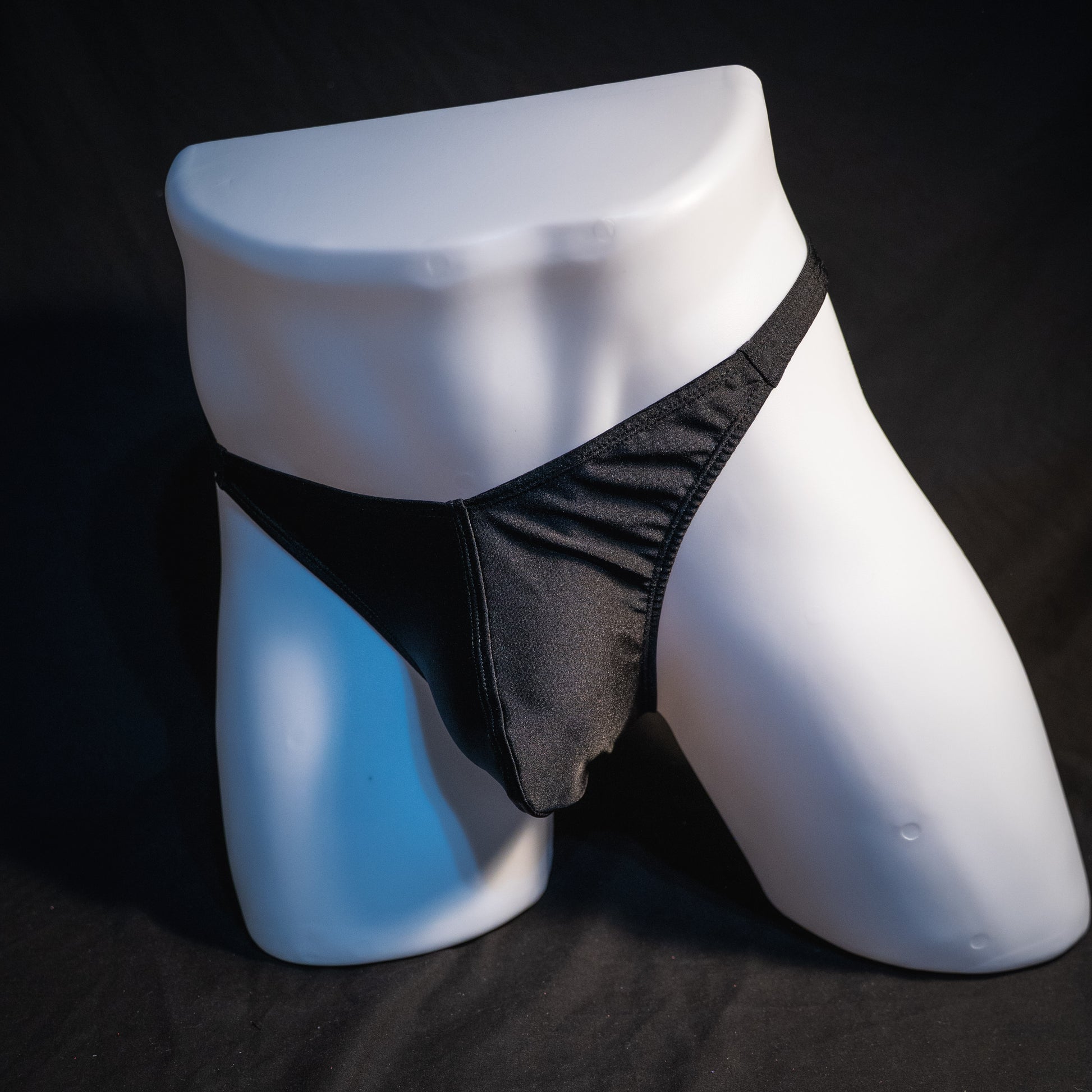 Men's solid black spandex thong underwear. classic cut, full front view.