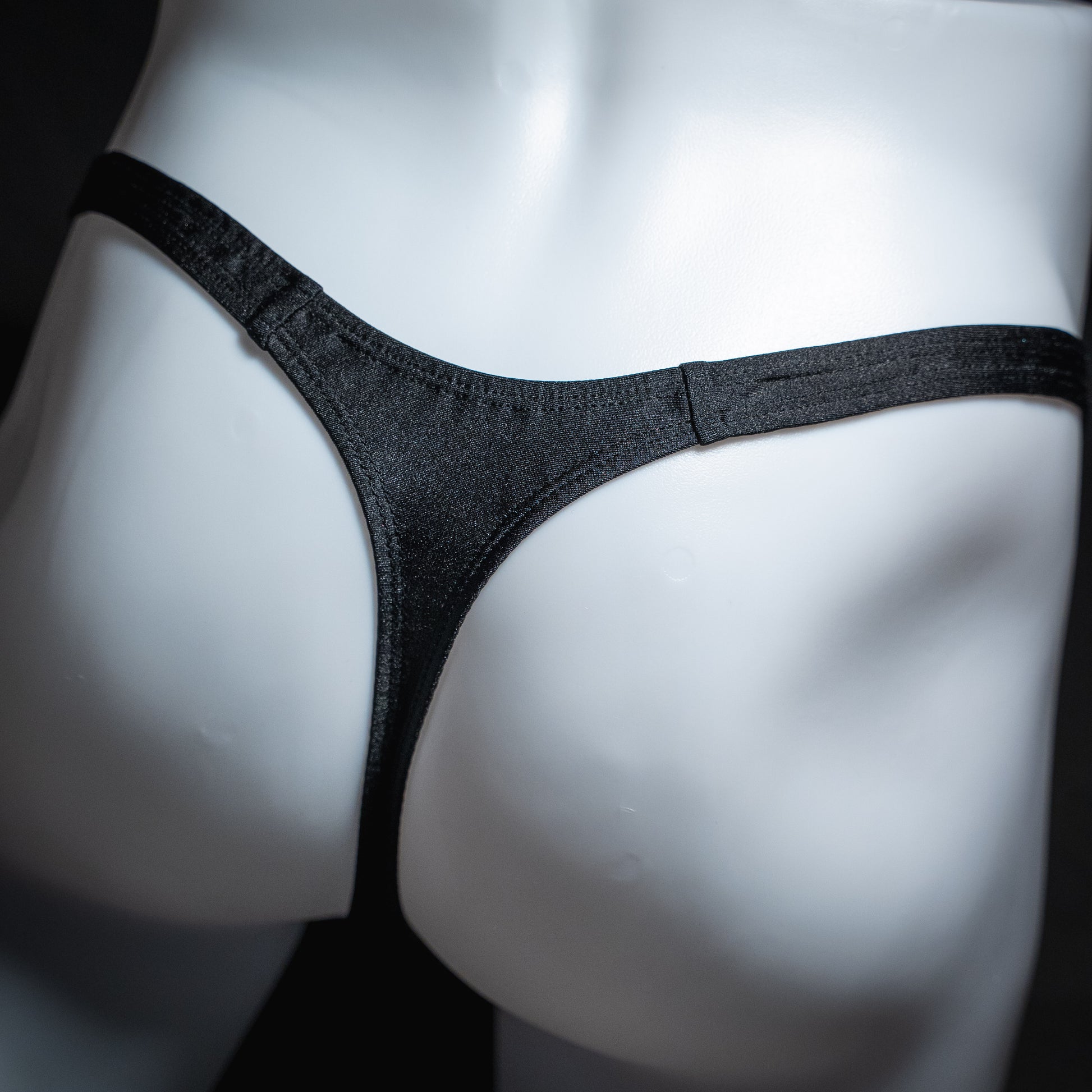 Men's solid black spandex thong underwear. classic cut, rear view.