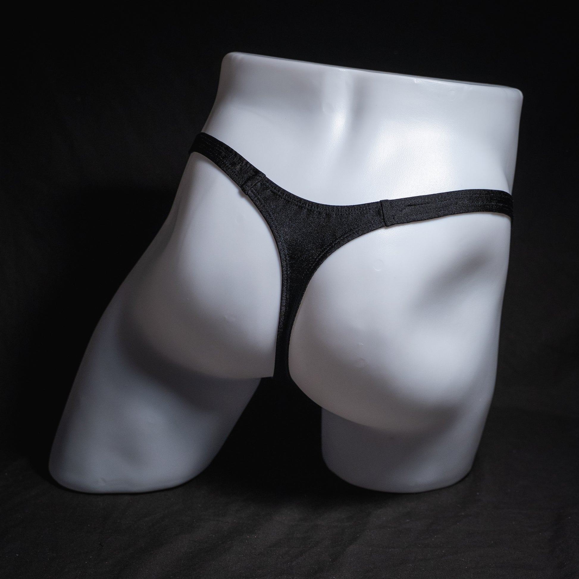 Men's solid black spandex thong underwear. classic cut, full rear view.