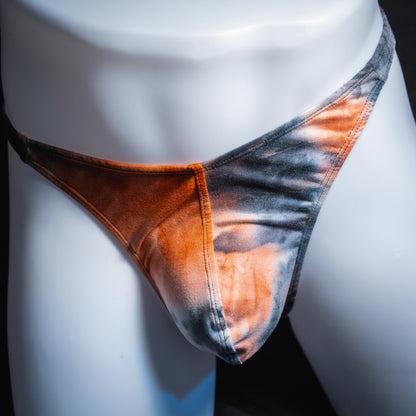 Men's black and red tie dye thong, classic cut, front view.