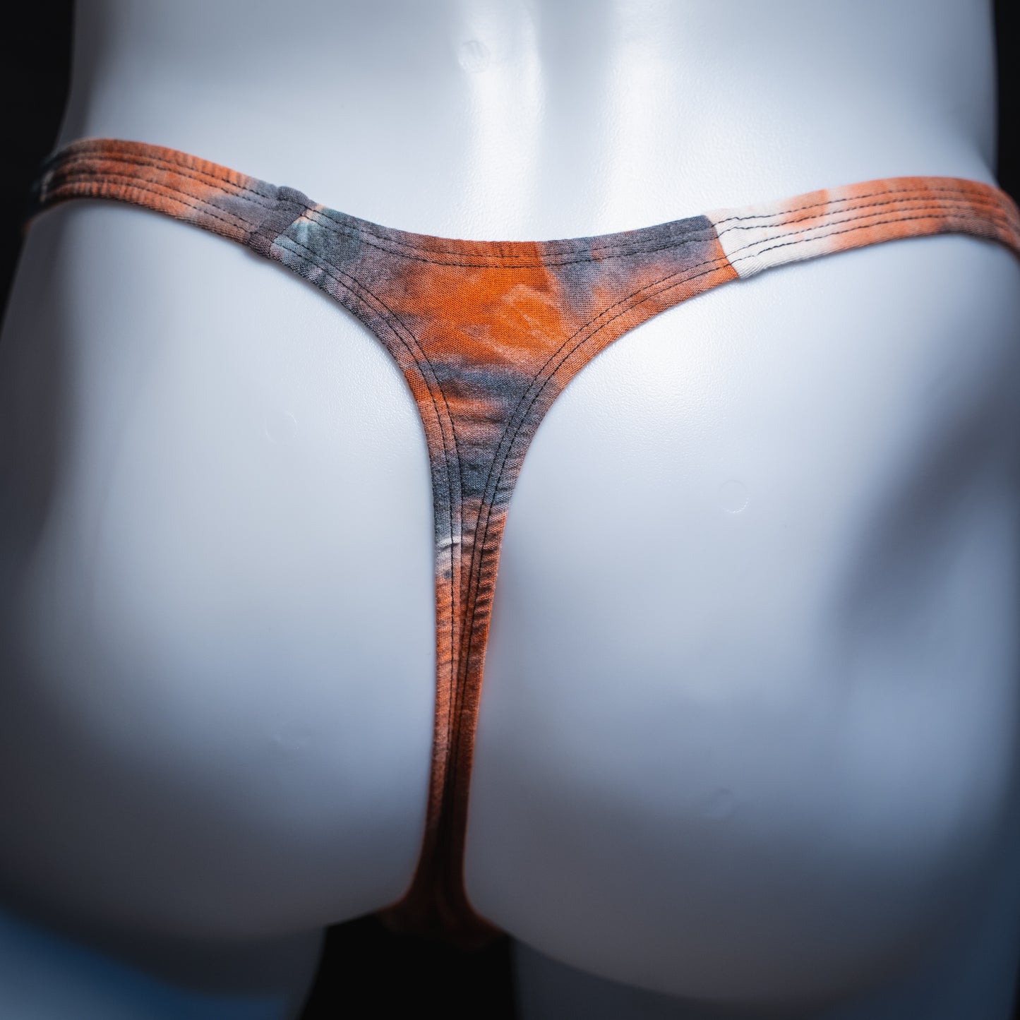 Men's black and red tie dye thong, classic cut, rear view.
