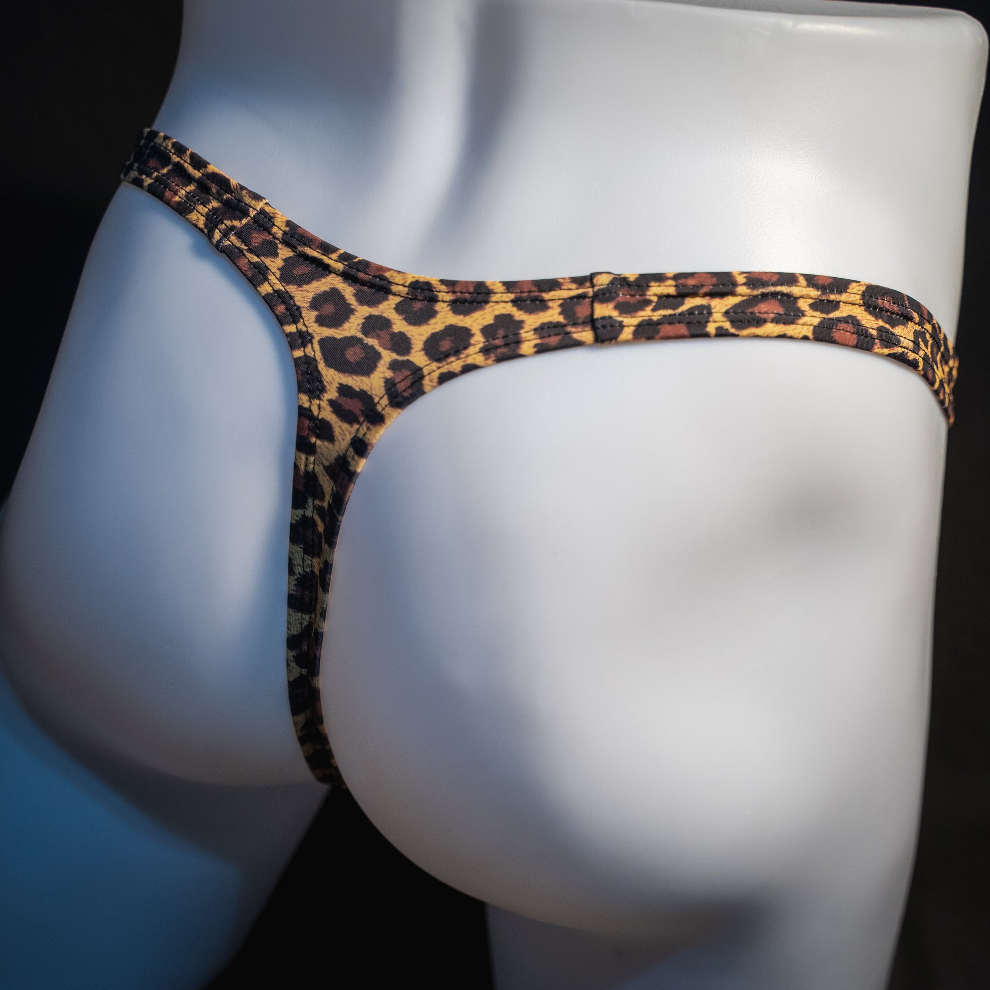 Men's brown leopard thong underwear, slim cut, angled rear view.