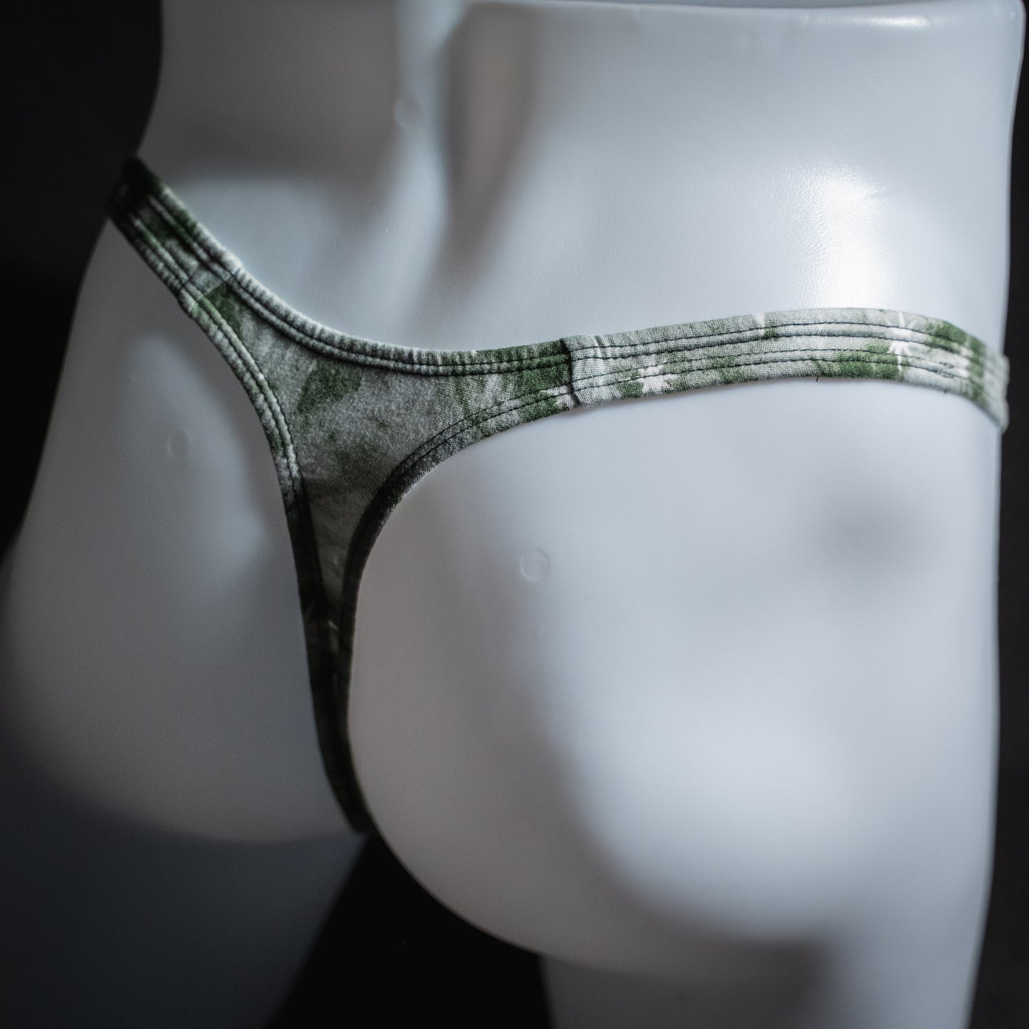 Men's gray sky with stars thong underwear, classic cut, angled rear view.