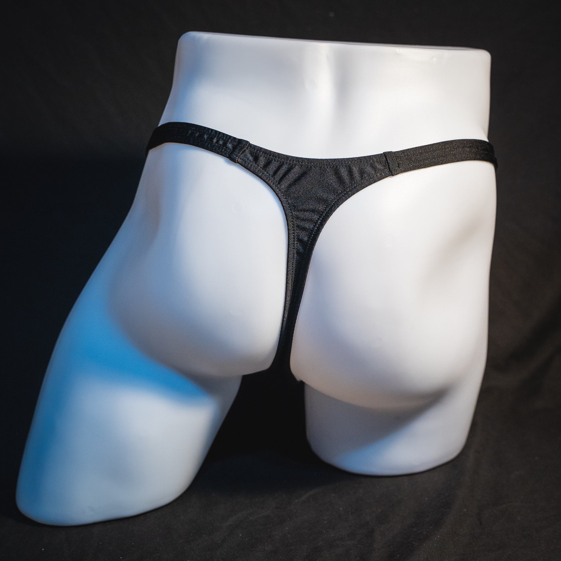 Men's half mesh solid black thong underwear, classic cut, full rear view.