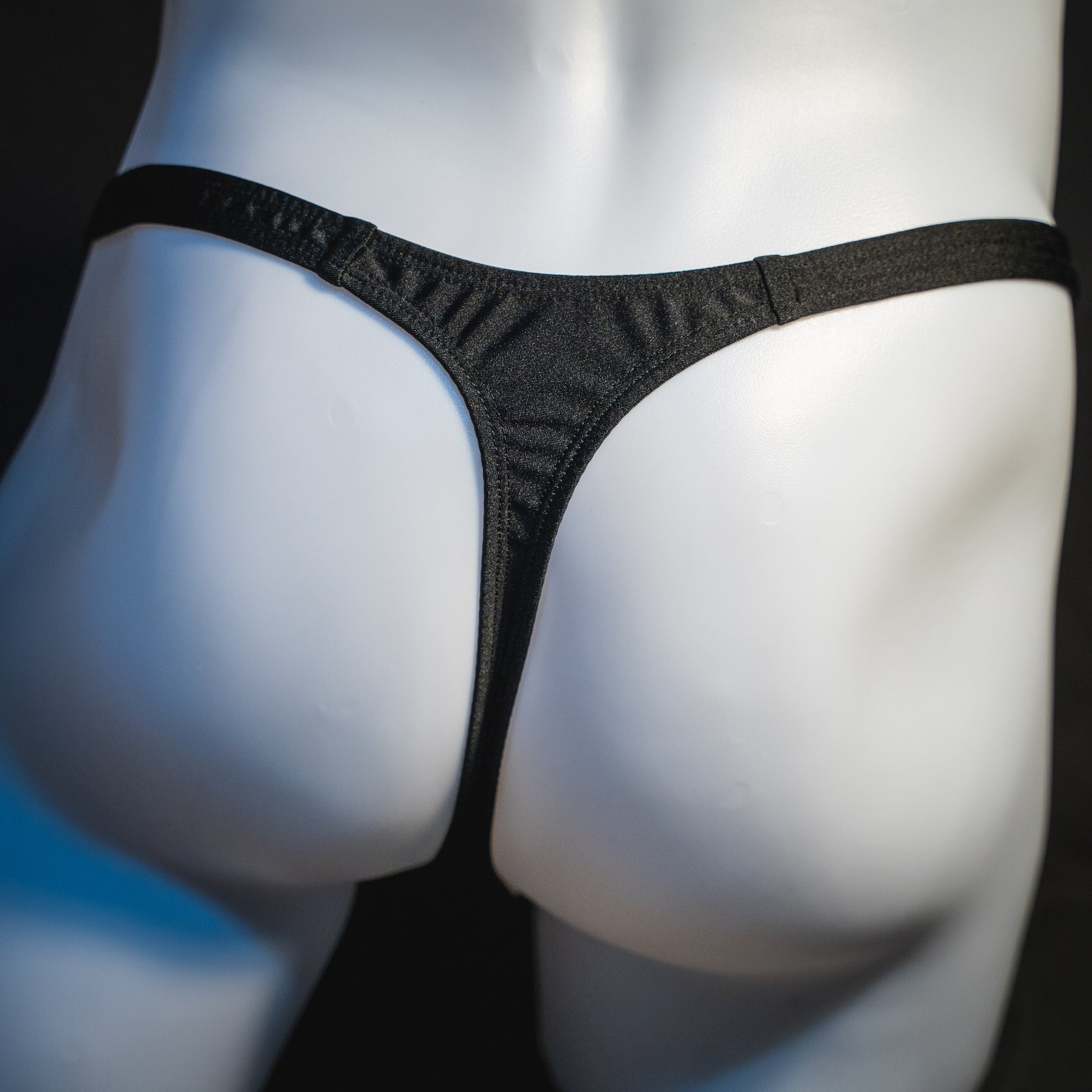 Men's half mesh solid black thong underwear, classic cut, rear view.