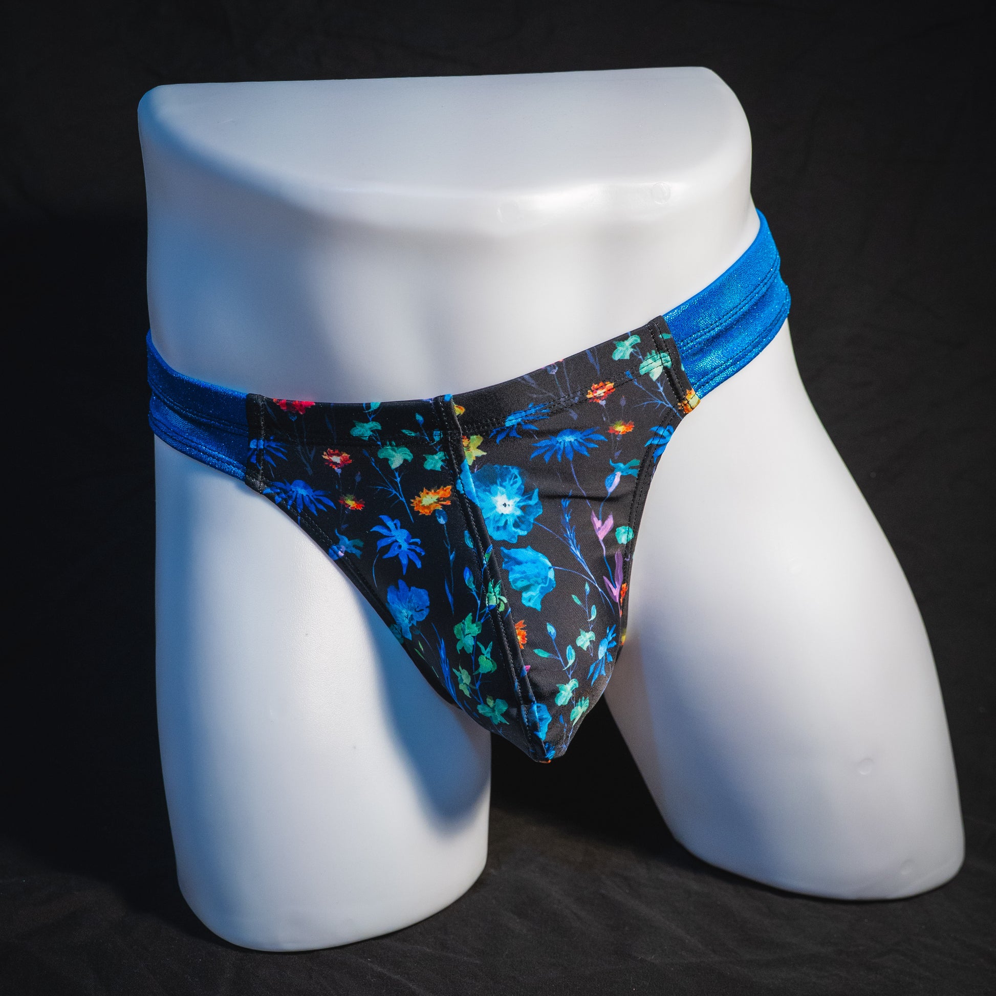 Men's floral thong underwear with metallic blue straps, robust cut, full front view.