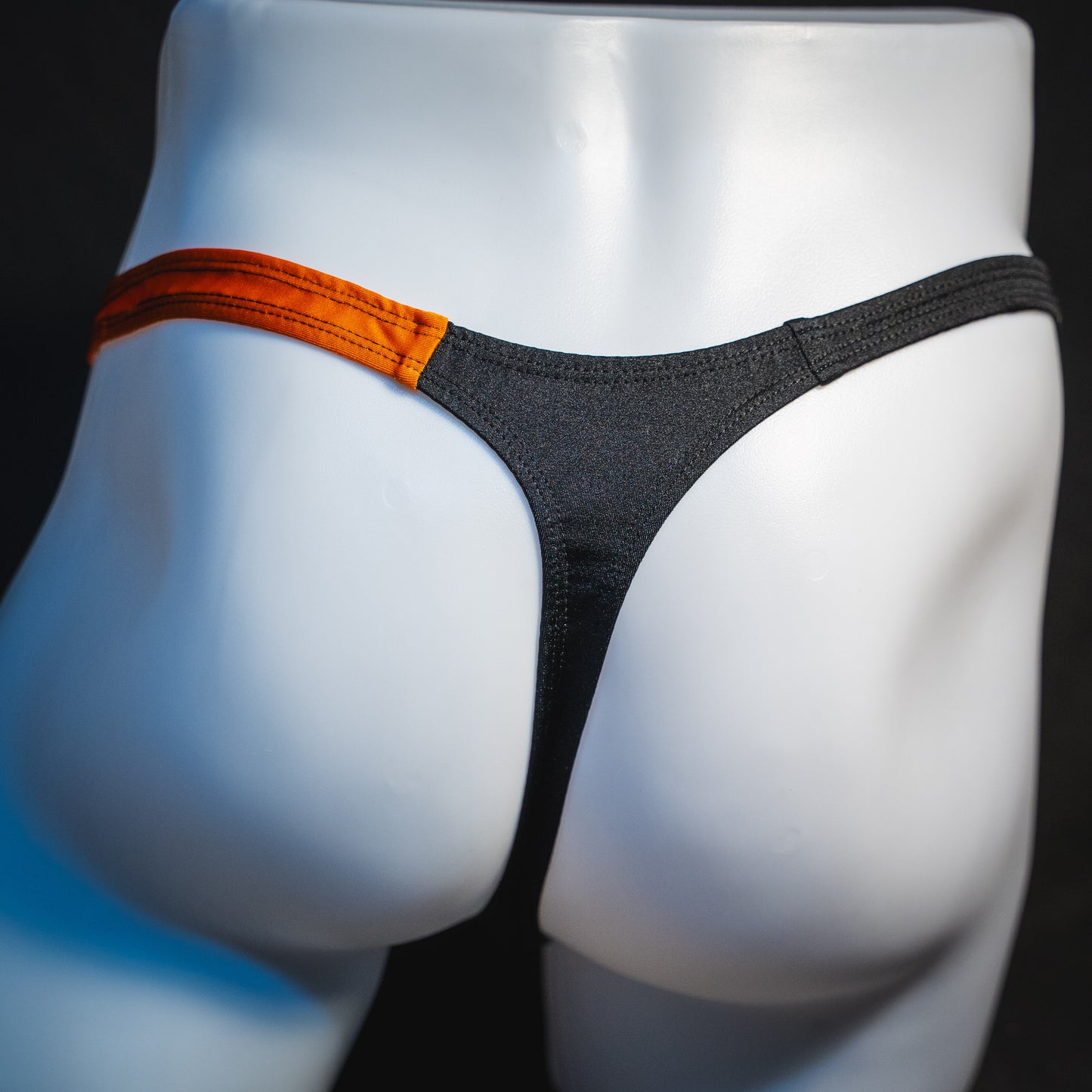 Men's orange and black asymmetrical Halloween thong, classic cut, rear view.