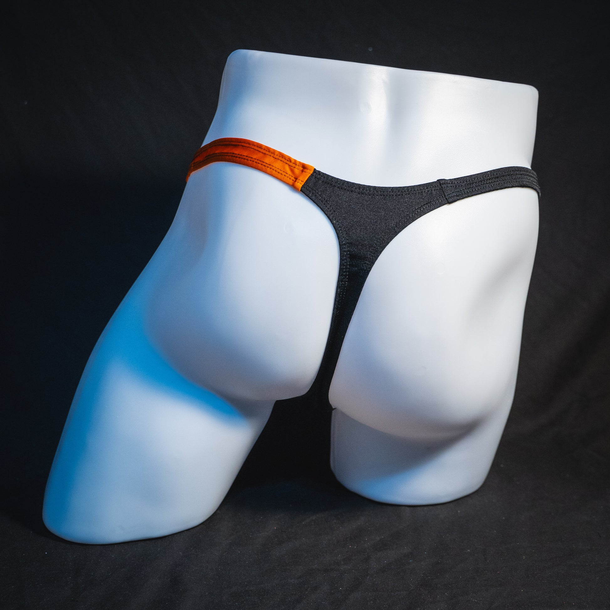 Men's orange and black asymmetrical Halloween thong, classic cut, full rear view.