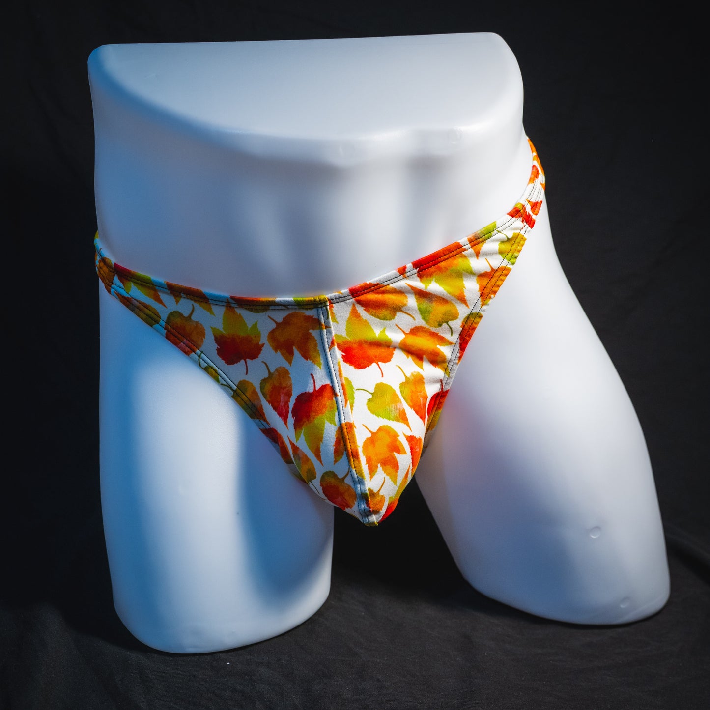 Men's orange autumn leaves thong underwear, classic cut, full front view.
