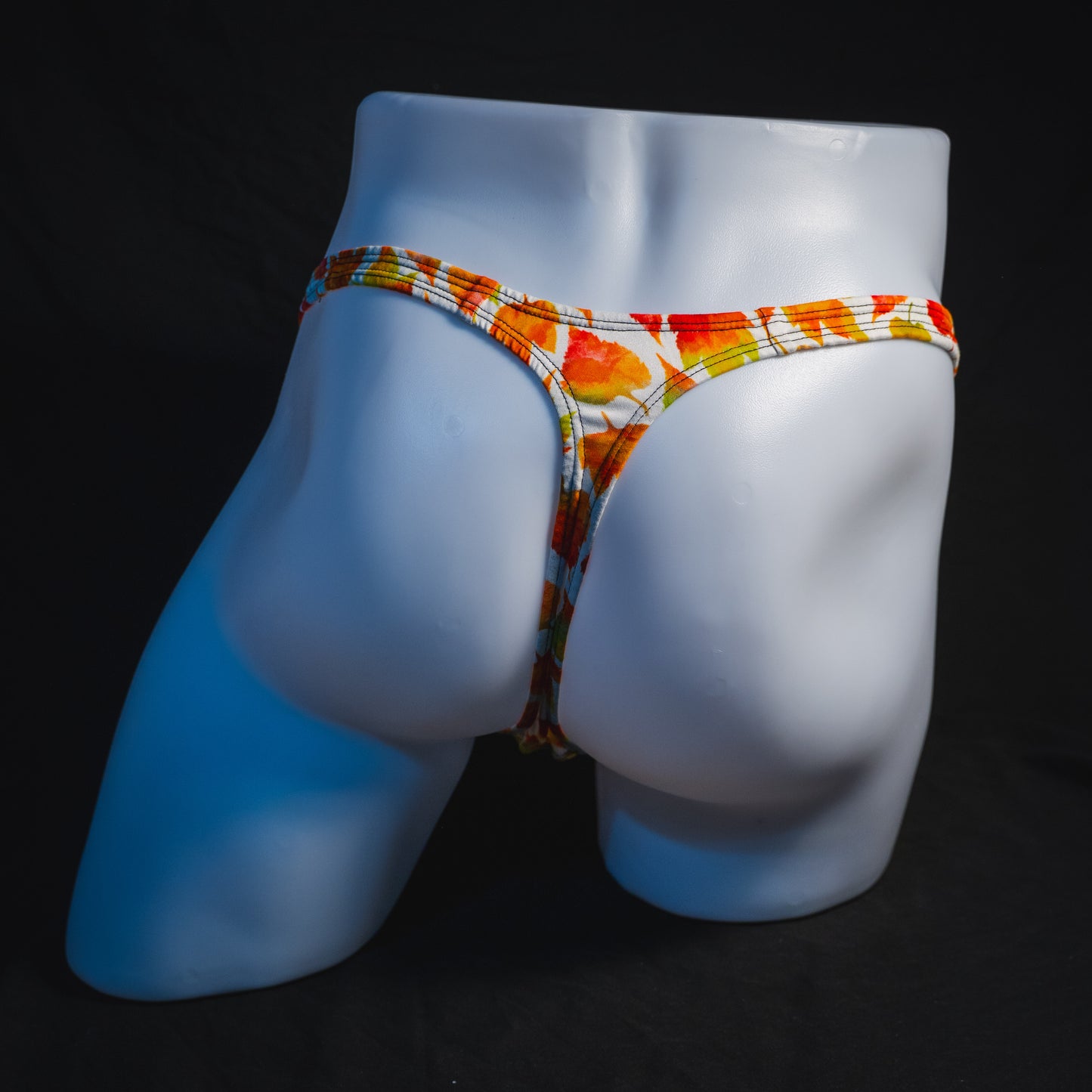 Men's orange autumn leaves thong underwear, classic cut, full rear view.