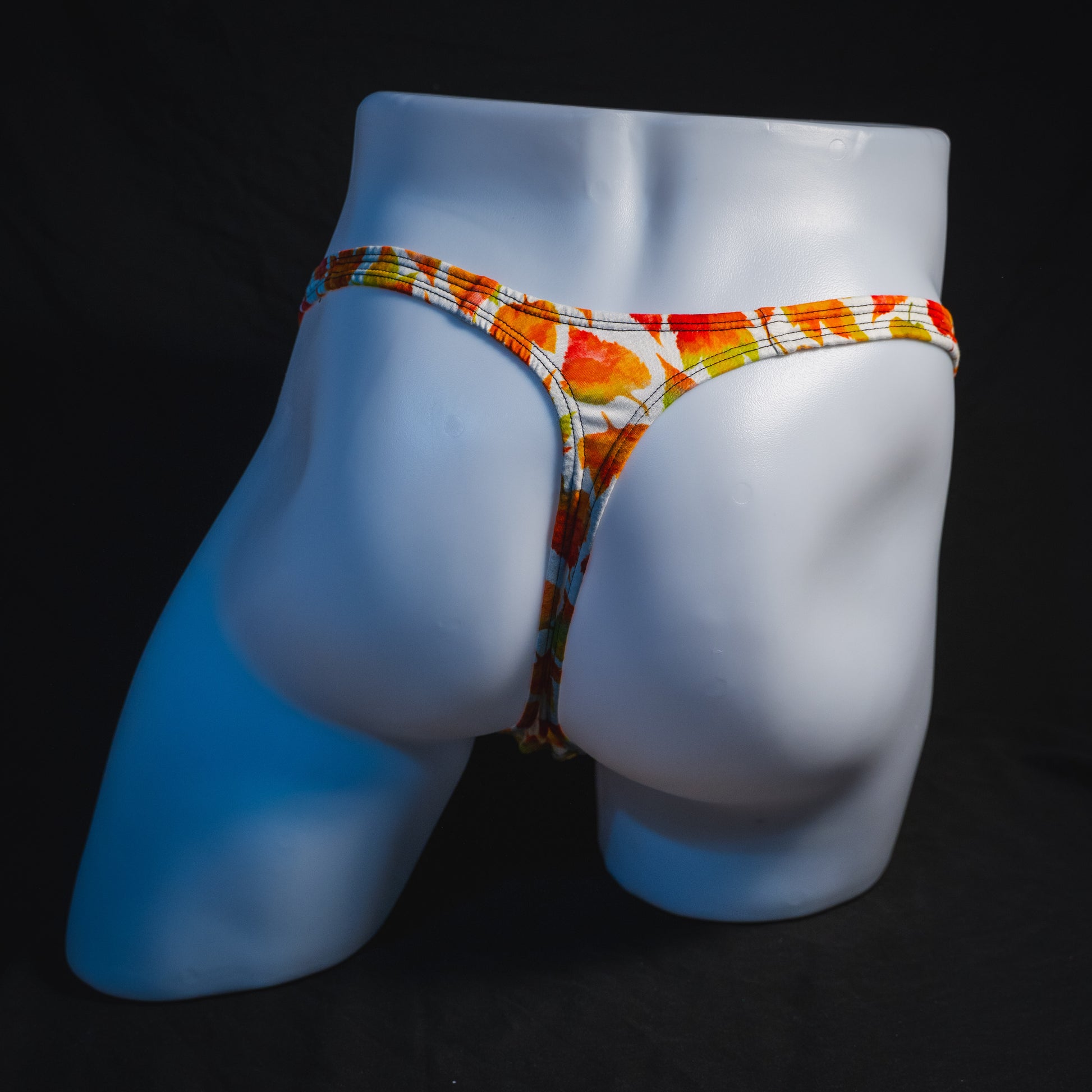 Men's orange autumn leaves thong underwear, classic cut, full rear view.