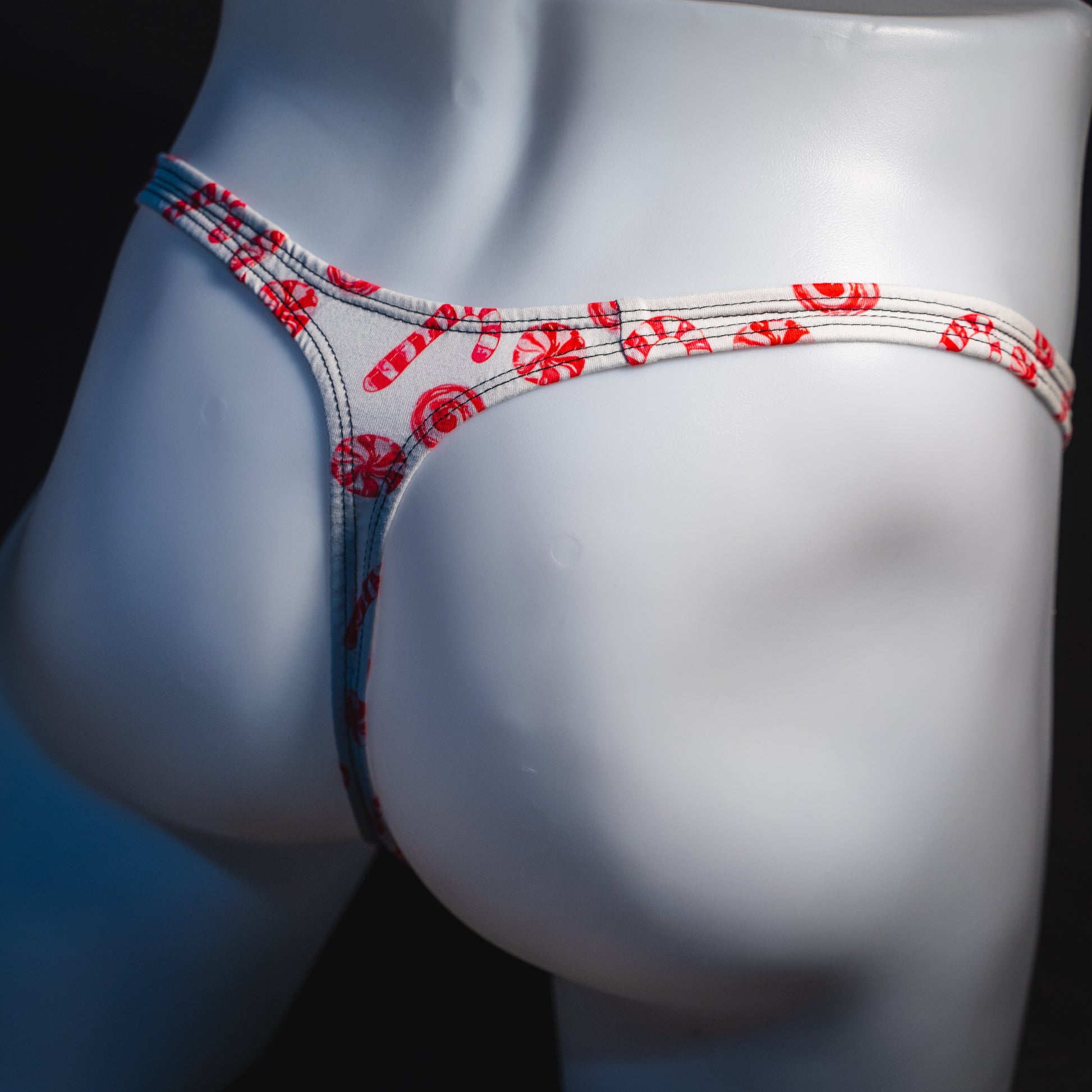 Men's peppermint candies Christmas thong underwear, classic cut, angled rear view.