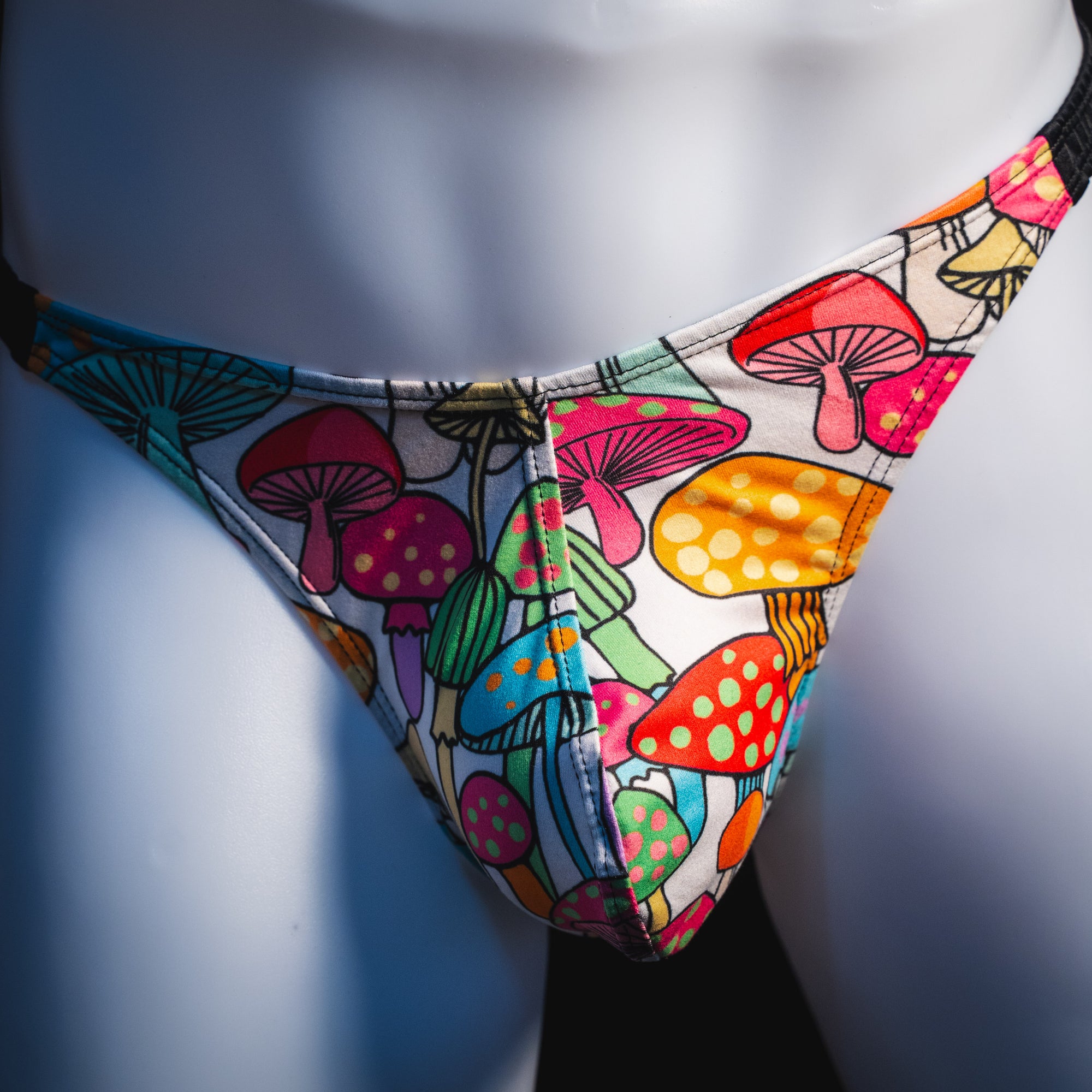 Men's colorful mushroom thong underwear, classic cut, front view.