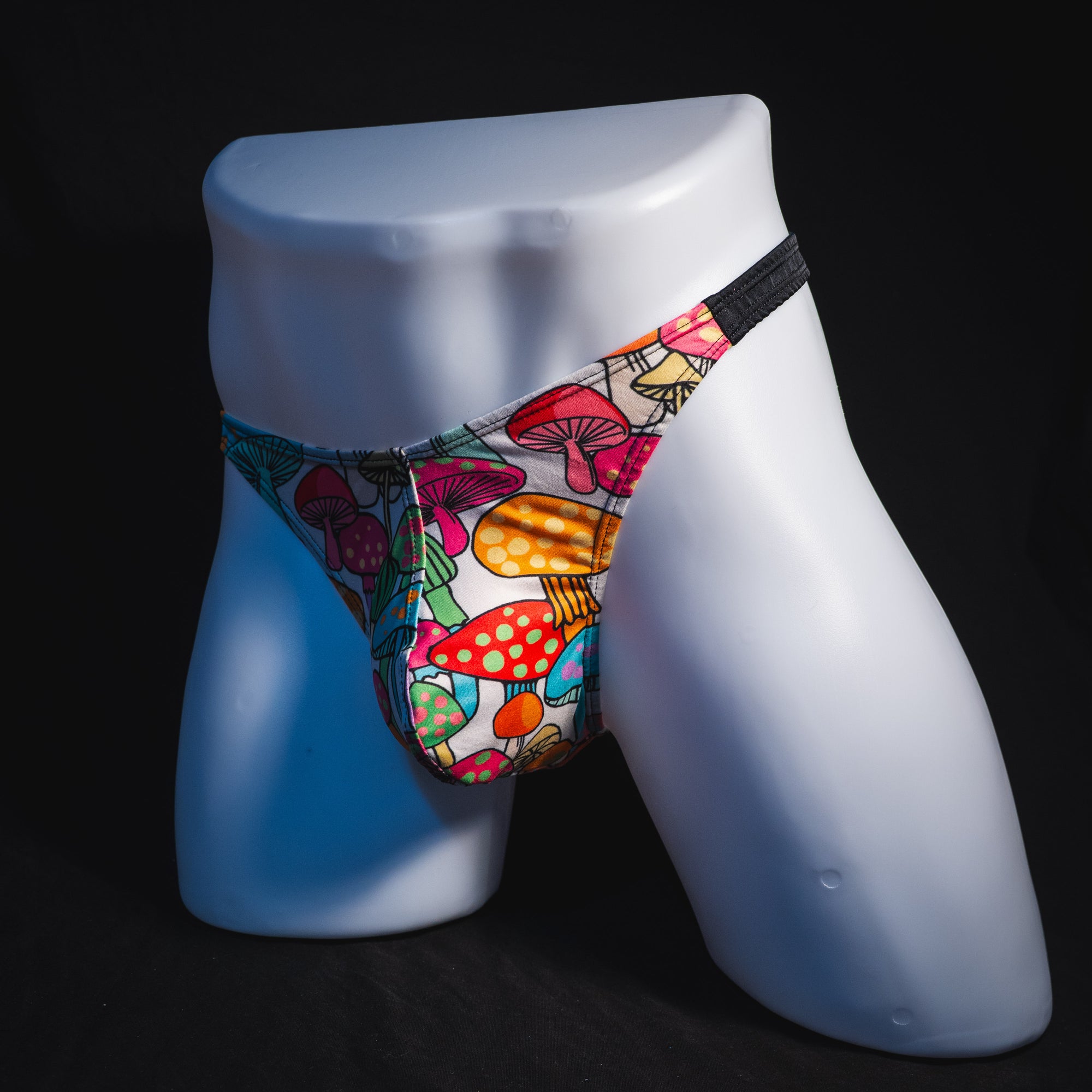 Men's colorful mushroom thong underwear, classic cut, full angled front view.