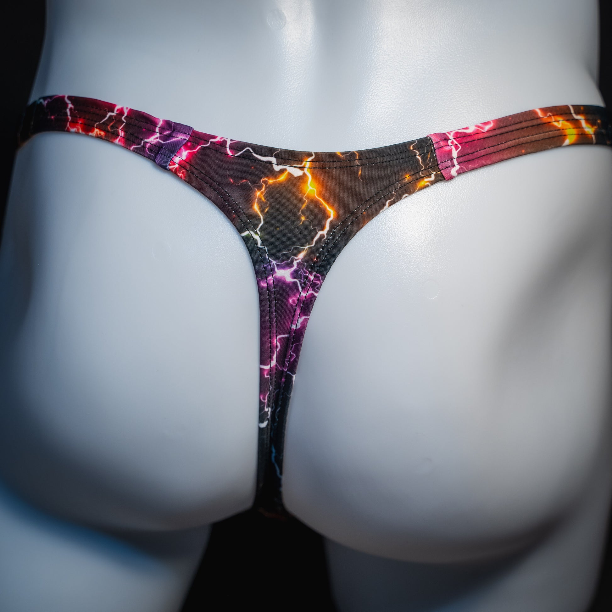 Men's purple lightning thong underwear, slim cut, rear view.