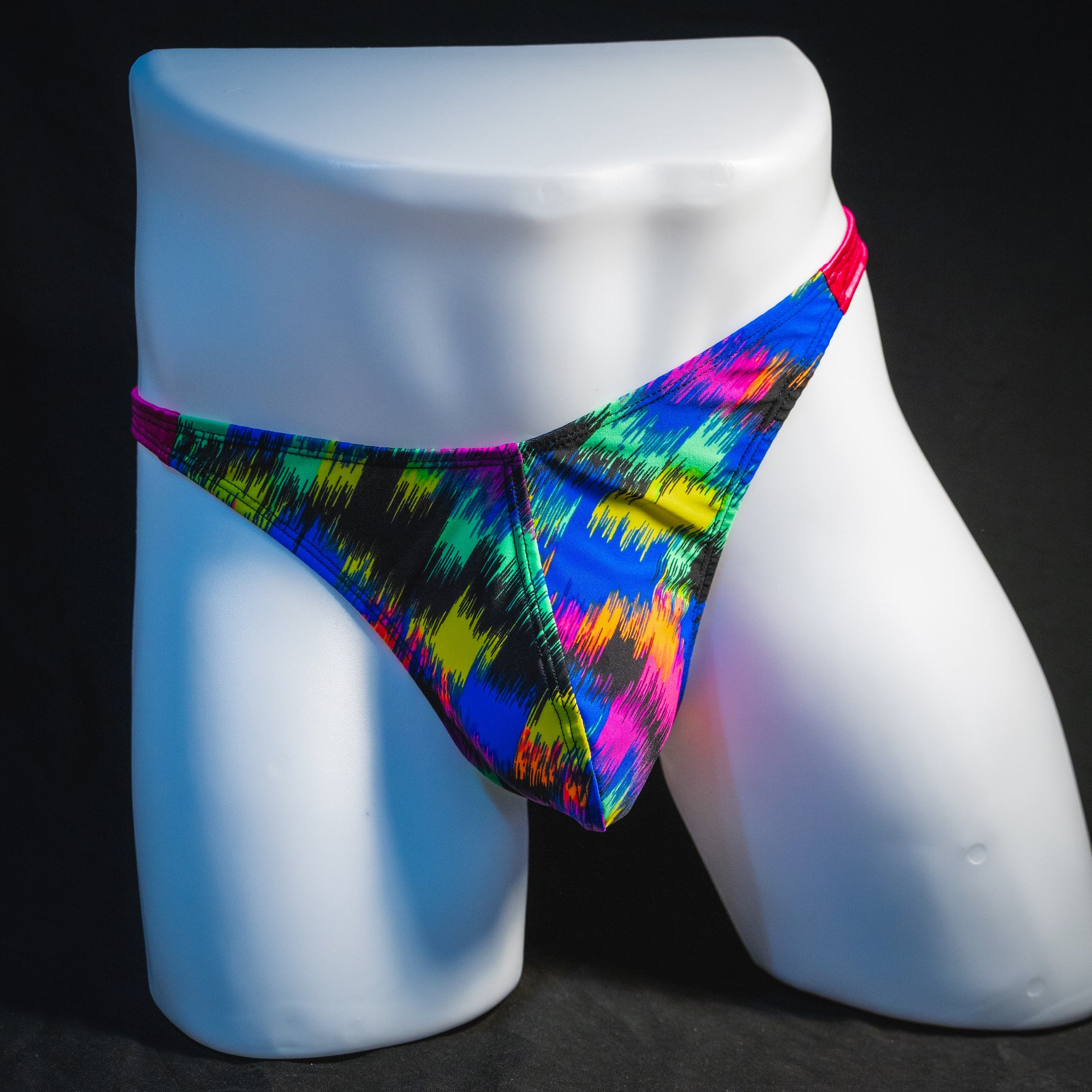 Men's rainbow splash with pink straps thong underwear, classic cut, full front view.