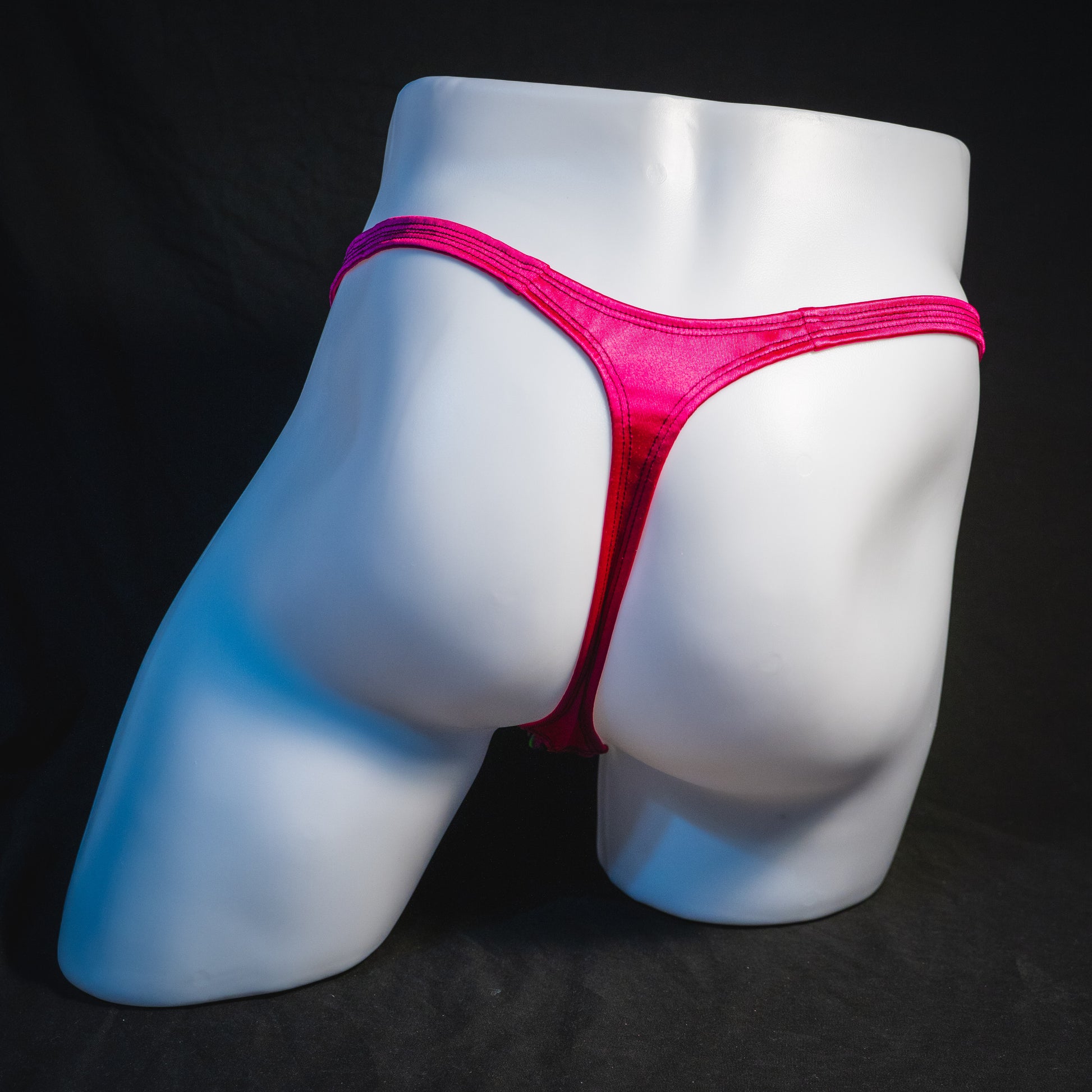 Men's rainbow splash with pink straps thong underwear, classic cut, full rear view.