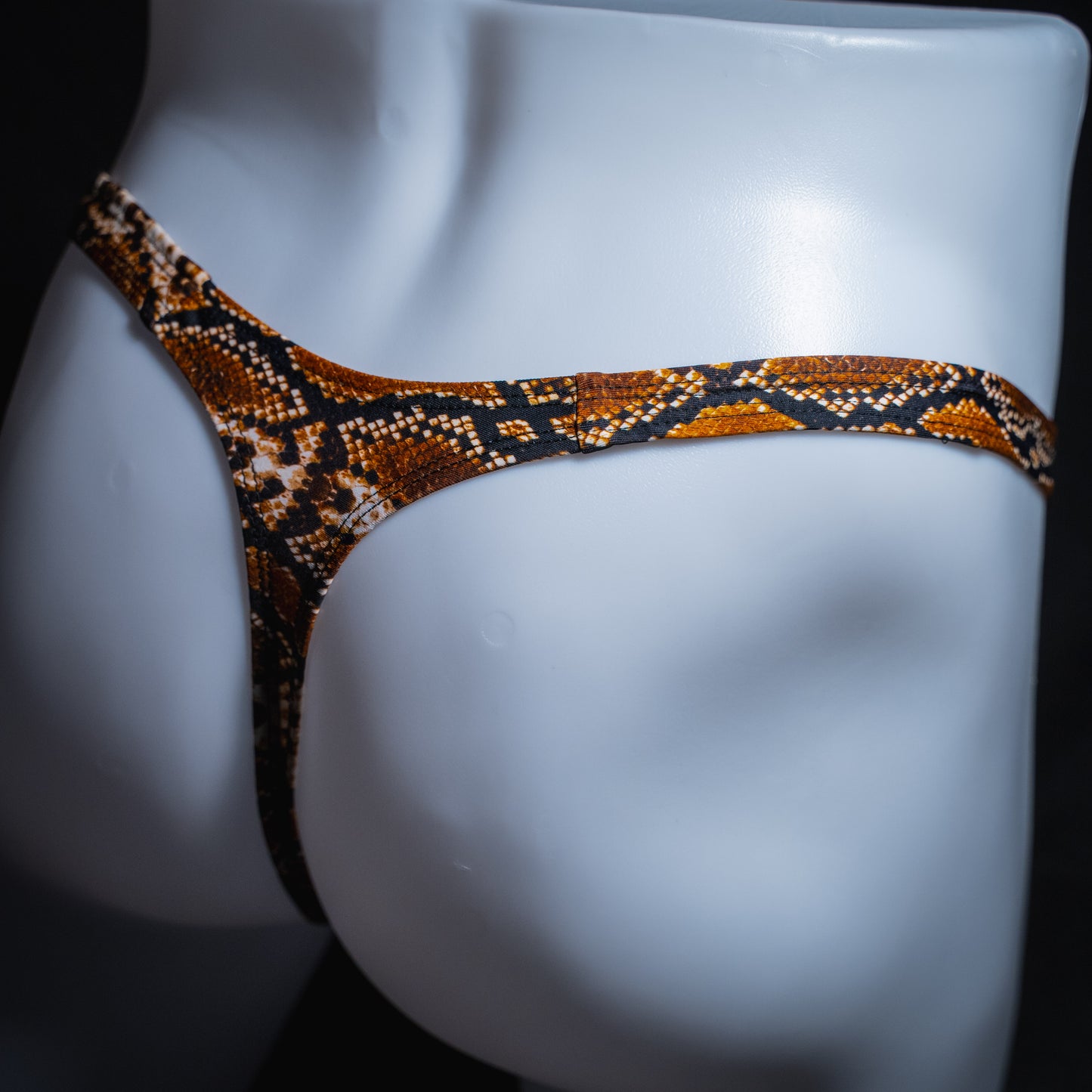 Men's rattlesnake thong underwear, slim cut, angled rear view.