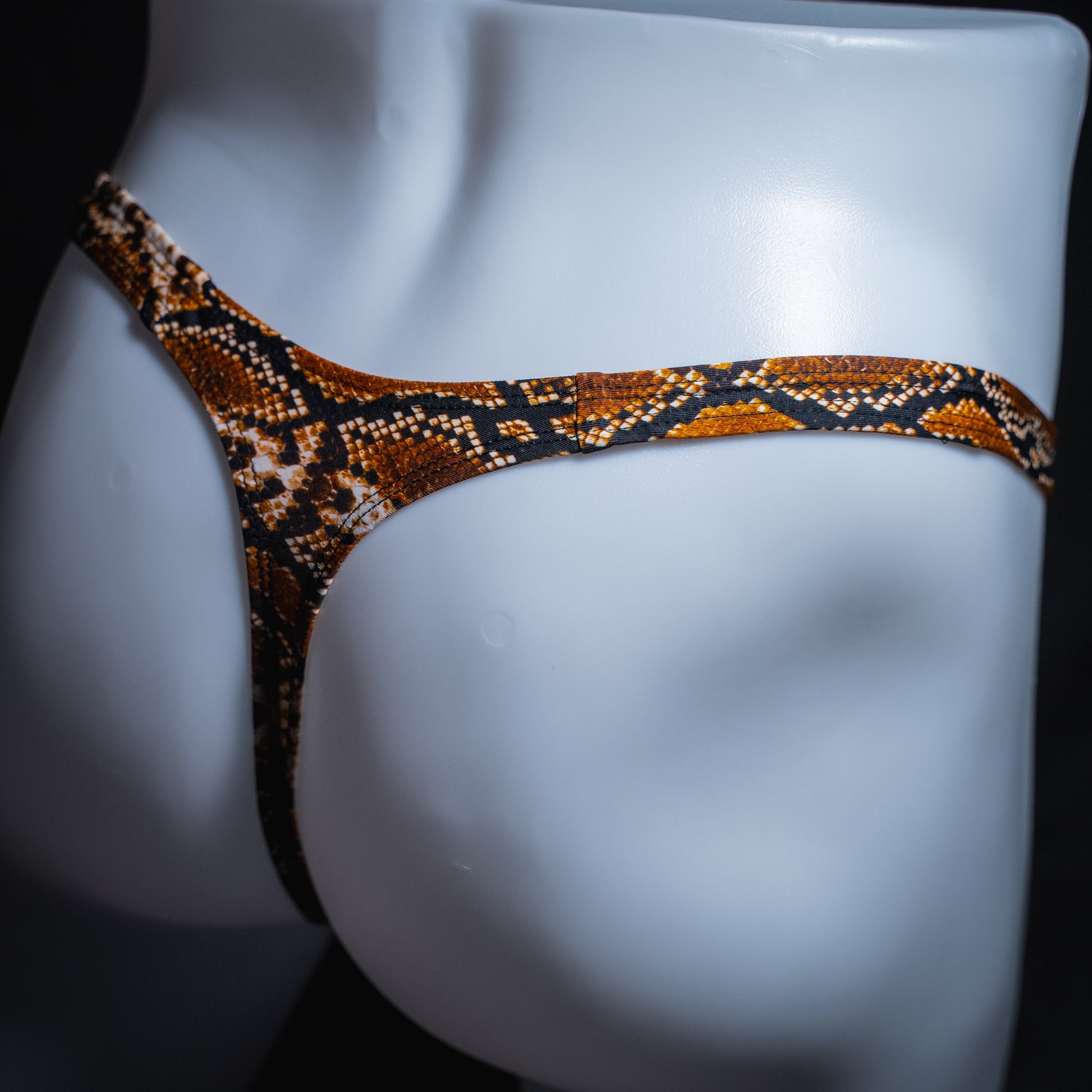 Men's rattlesnake thong underwear, slim cut, angled rear view.