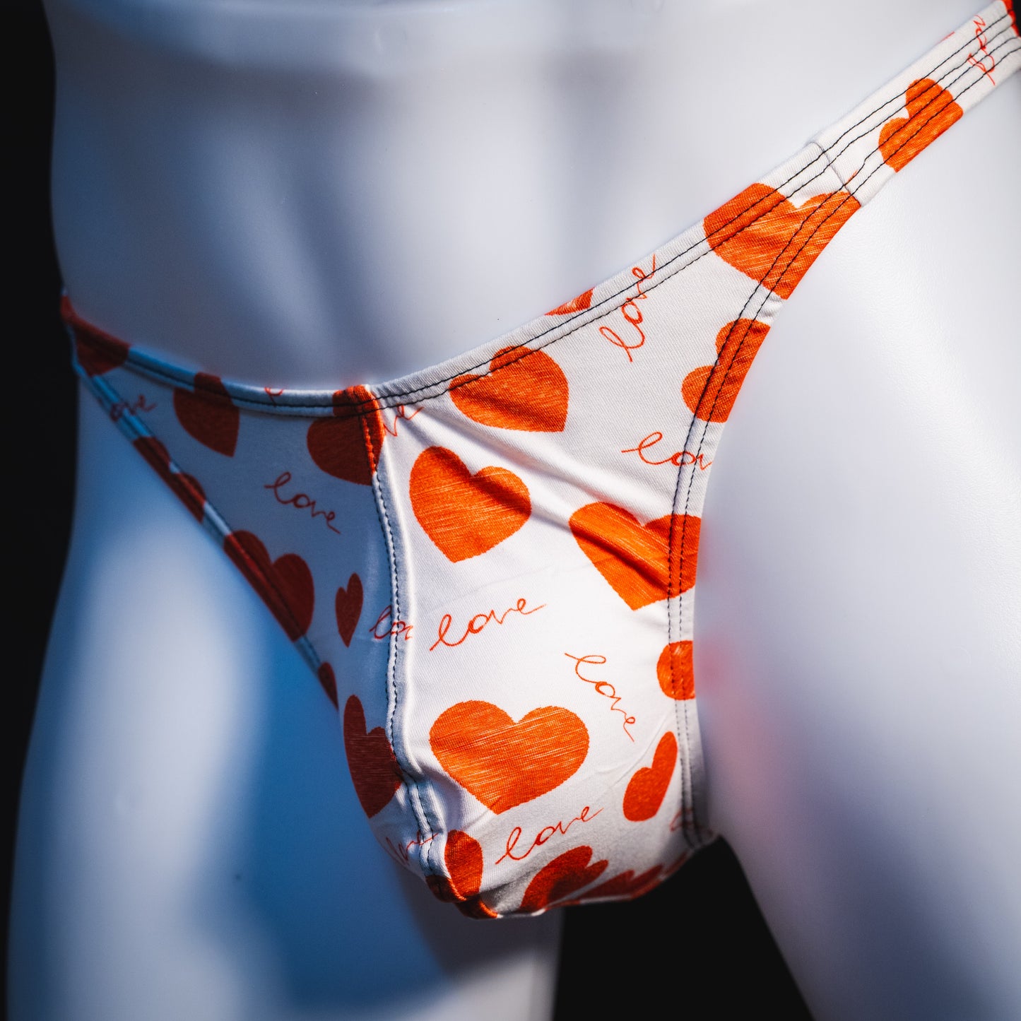 Men's red hearts Valentine's Day thong underwear, Classic cut, angled front view.