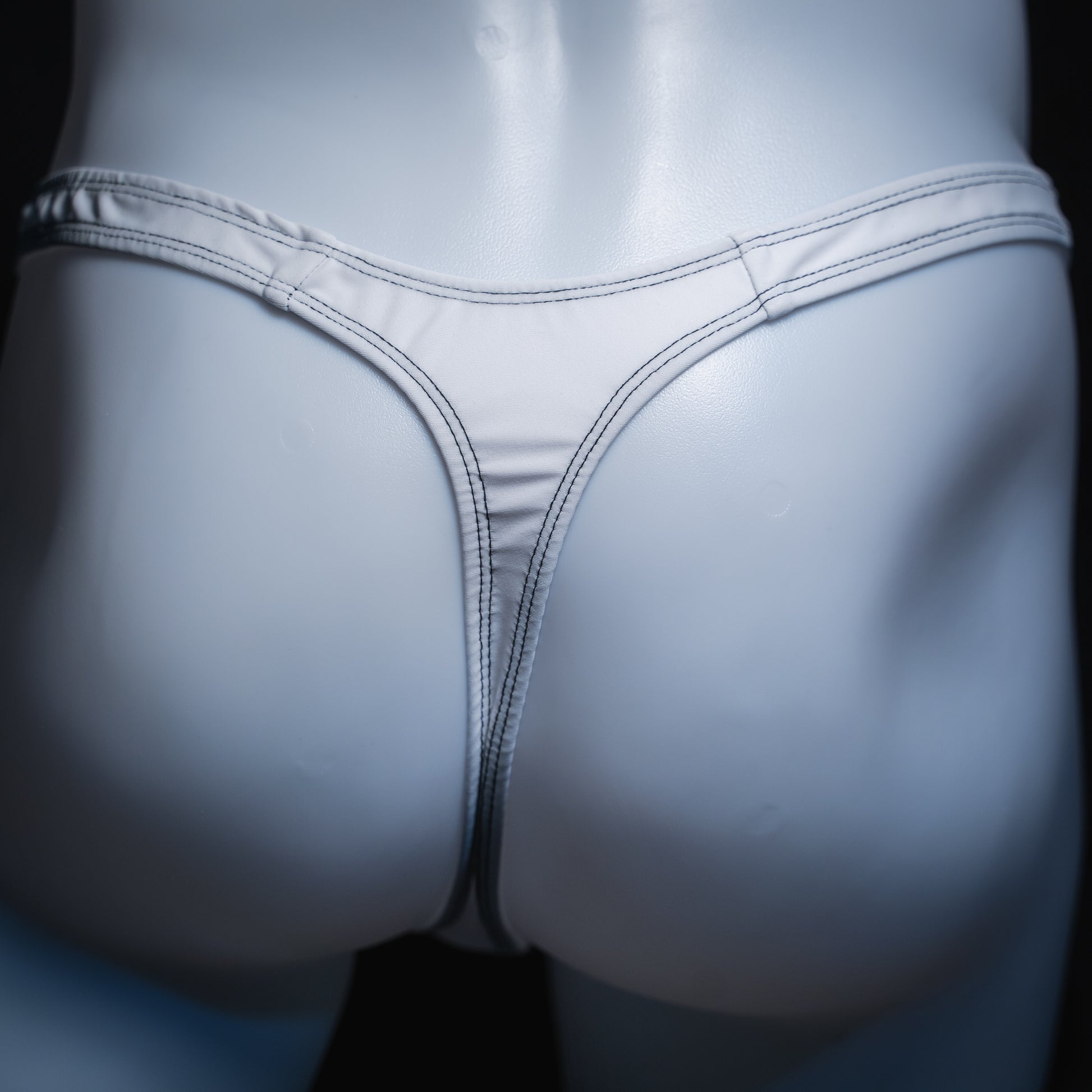 Men's solid white thong, slim cut, rear view.