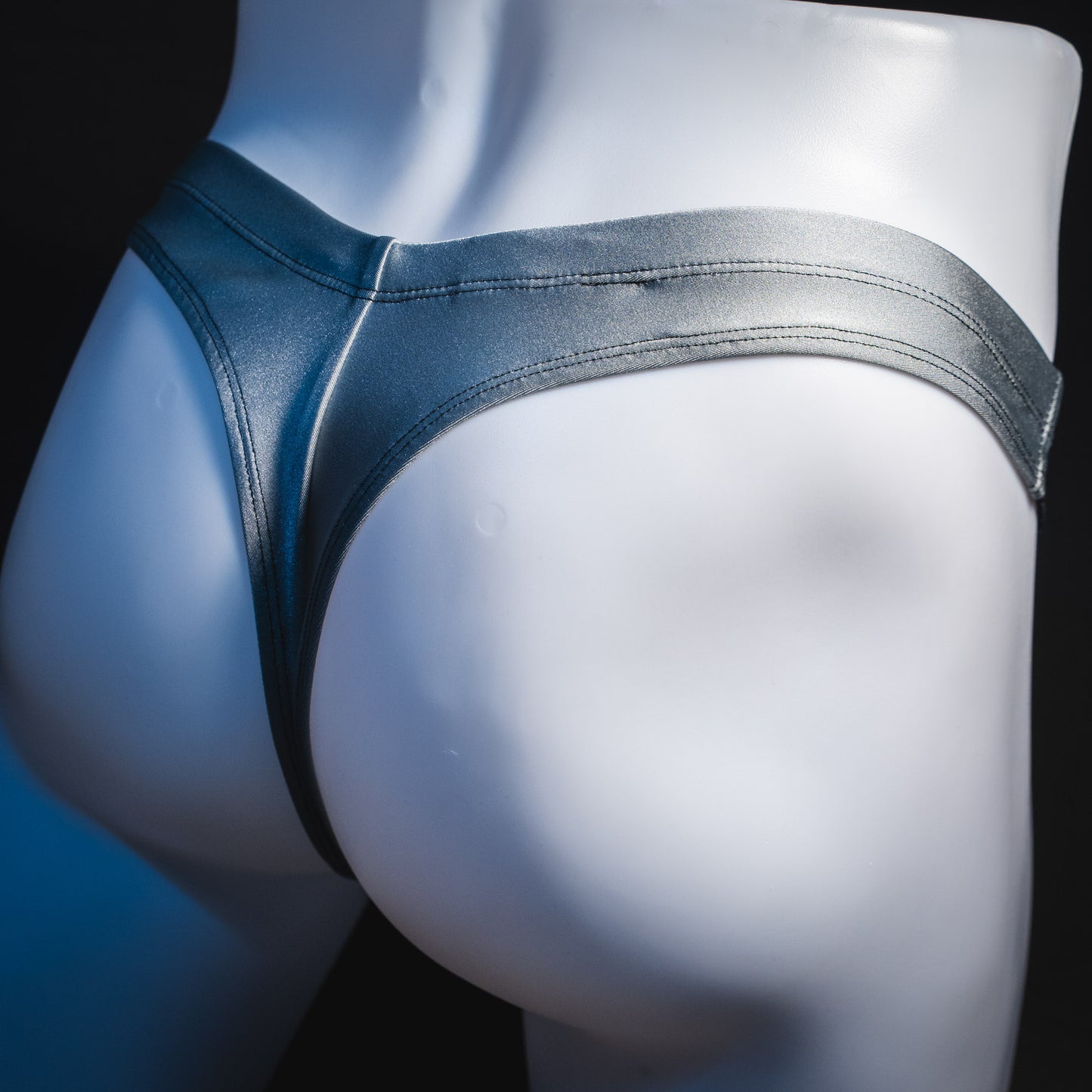 Men's silver with black mesh panels thong underwear, contour cut, rear view.