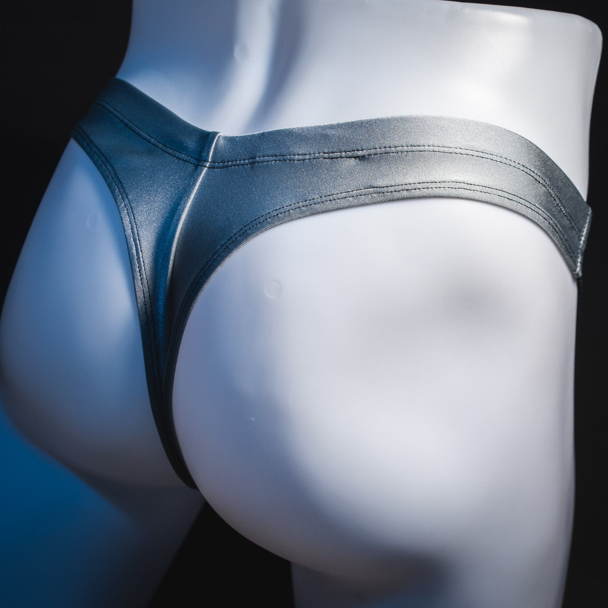 Men's silver with black mesh panels thong underwear, contour cut, rear view.