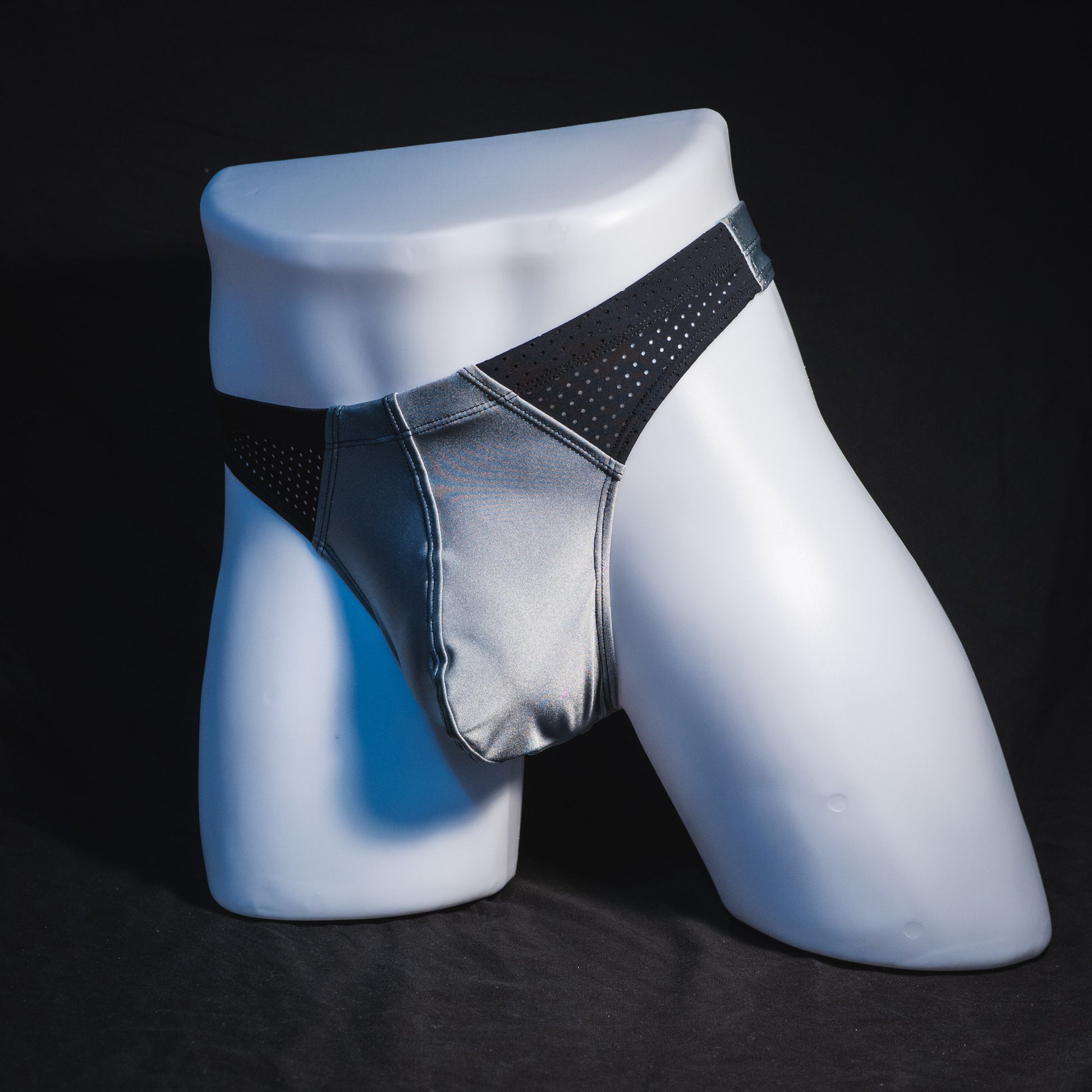 Men's silver with black mesh panels thong underwear, contour cut, full front angled view.