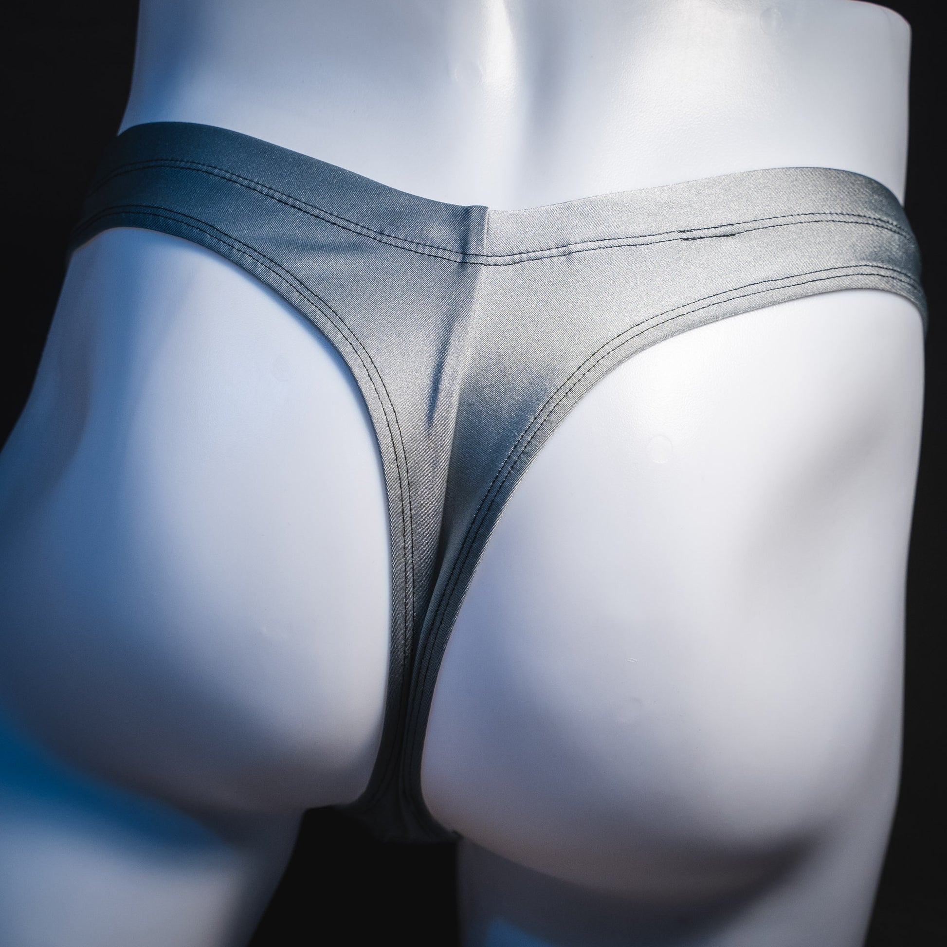 Men's silver with black mesh panels thong underwear, contour cut, rear view.